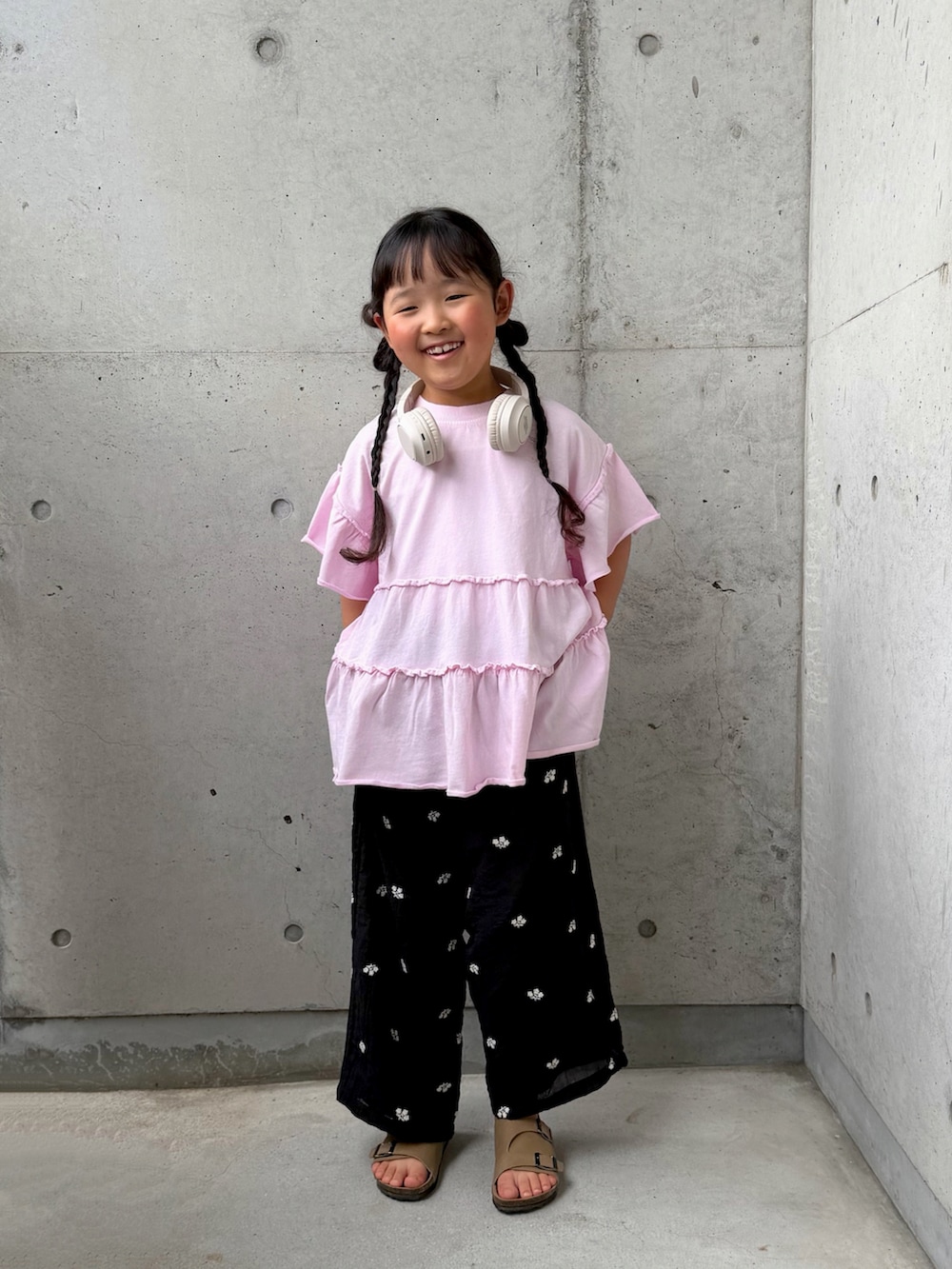 ピンク系のTシャツ/カットソー、ブラック系のその他パンツ、ベージュ系のサンダルを着用したキッズの春コーディネートの3枚目の写真