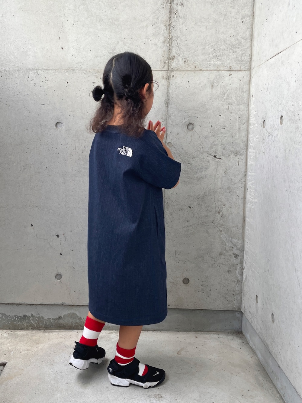 ブラック系のサンダル、ブルー系のワンピース、ベージュ系のハットを着用したキッズの夏コーディネートの5枚目の写真