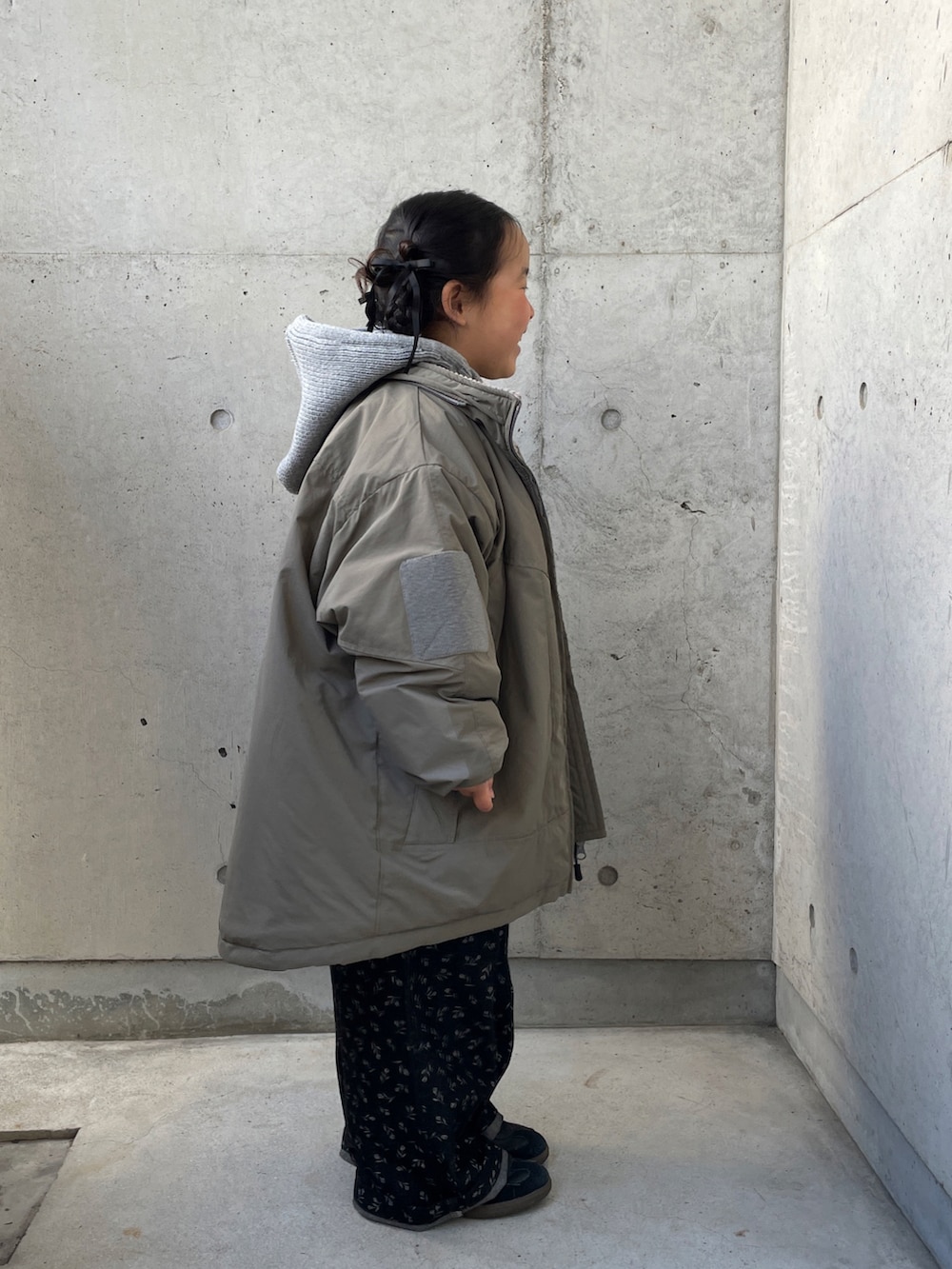 ピンク系のニット/セーター、ブラック系のオールインワン・サロペット、グリーン系のブルゾンを着用したキッズの冬コーディネートの2枚目の写真