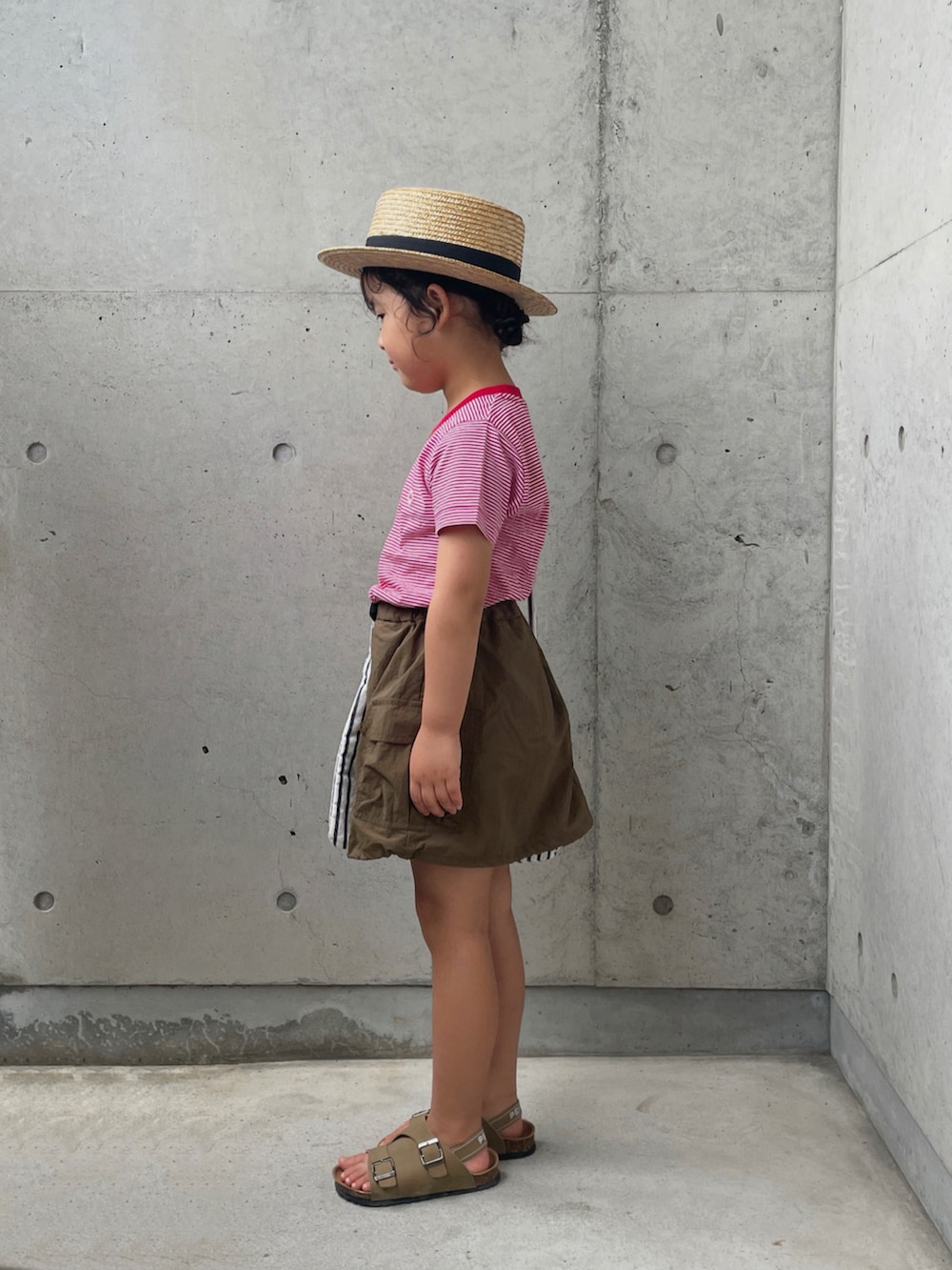 レッド系のTシャツ/カットソー、グリーン系のスカート、ホワイト系のバッグを着用したキッズの夏コーディネートの2枚目の写真