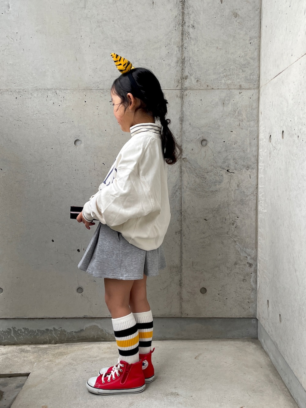 レッド系のスニーカー、ホワイト系のTシャツ/カットソー、ホワイト系のスウェットを着用したキッズの冬コーディネートの2枚目の写真