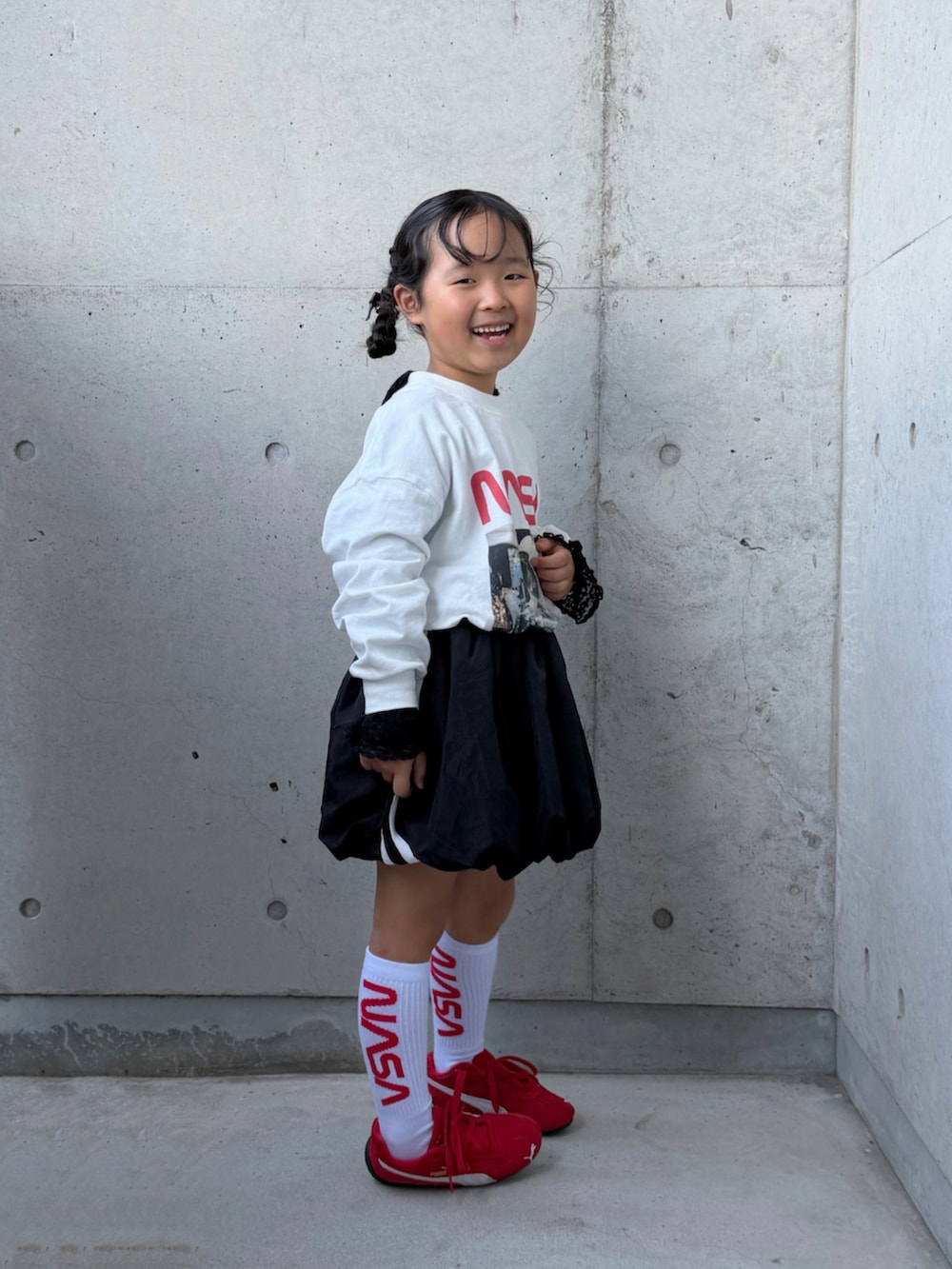 ブラック系のTシャツ/カットソー、ブラック系のスカート、ホワイト系のTシャツ/カットソーを着用したキッズの秋コーディネートの4枚目の写真