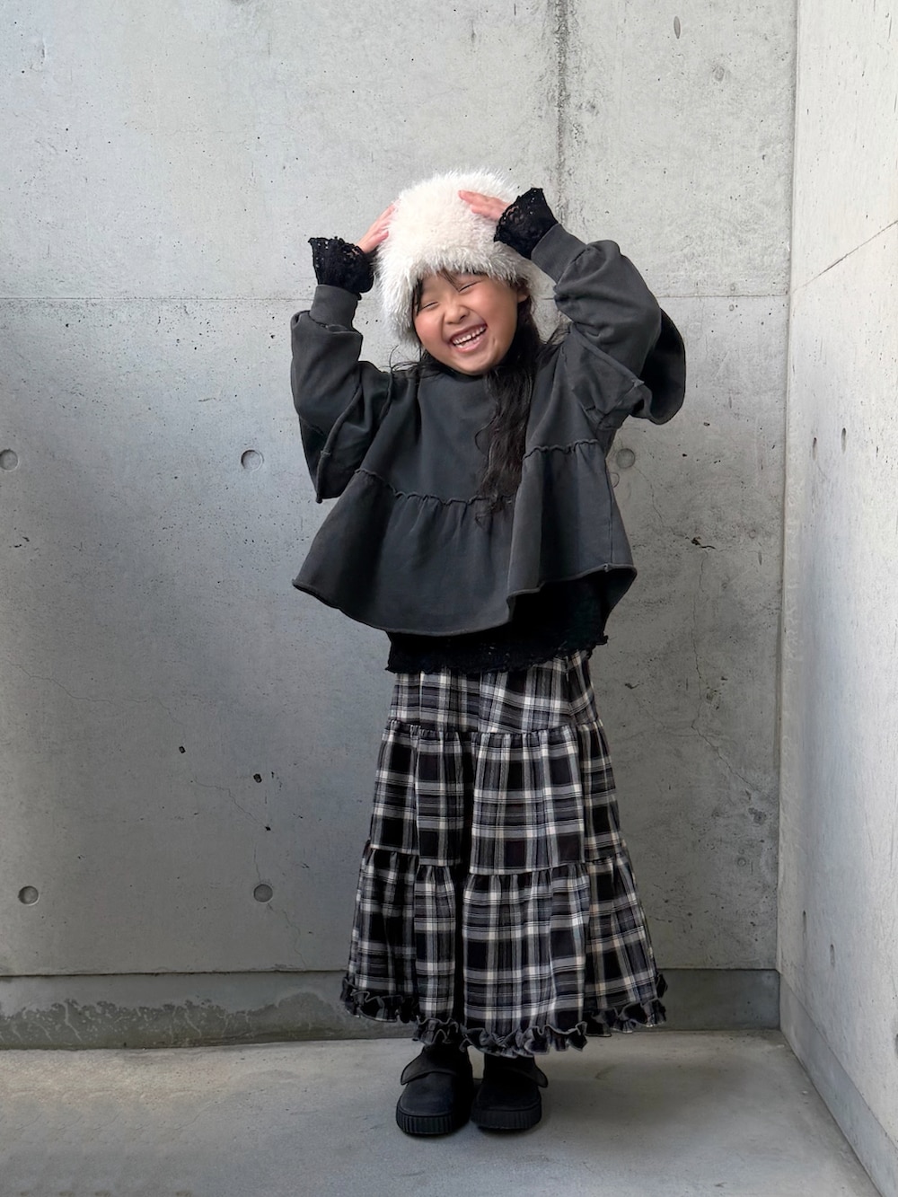 ブラック系のTシャツ/カットソー、グレー系のTシャツ/カットソー、ブラウン系のスカートを着用したキッズの冬コーディネートの3枚目の写真