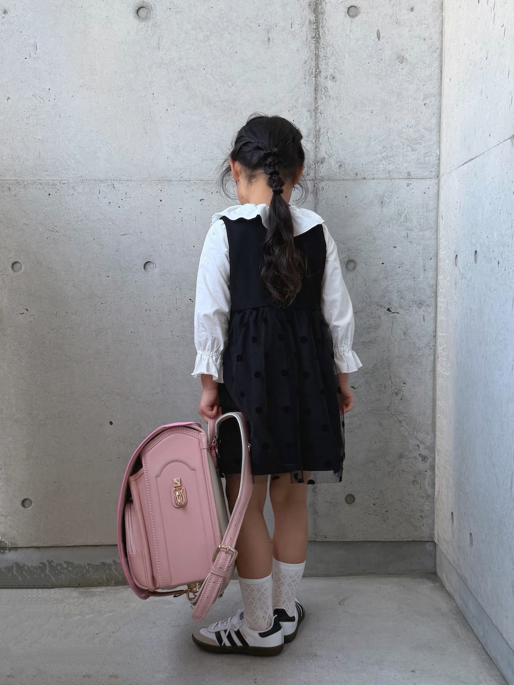 ホワイト系のシャツ/ブラウス、ブラック系のワンピース、ピンク系のトートバッグを着用したキッズの春コーディネートの3枚目の写真