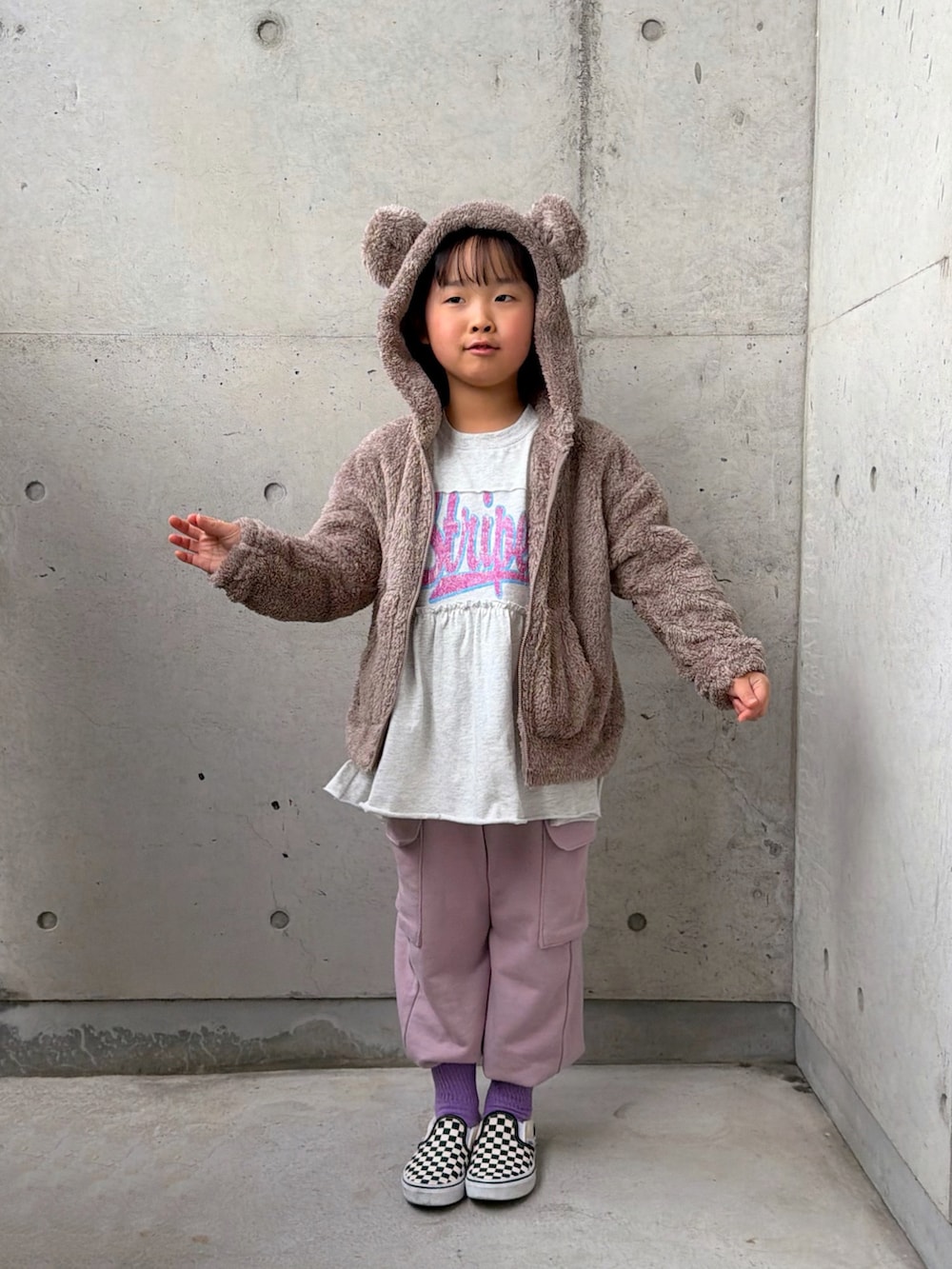 ブラック系のスリッポン、ピンク系のカーゴパンツ、グレー系のワンピースを着用したキッズの冬コーディネートの2枚目の写真