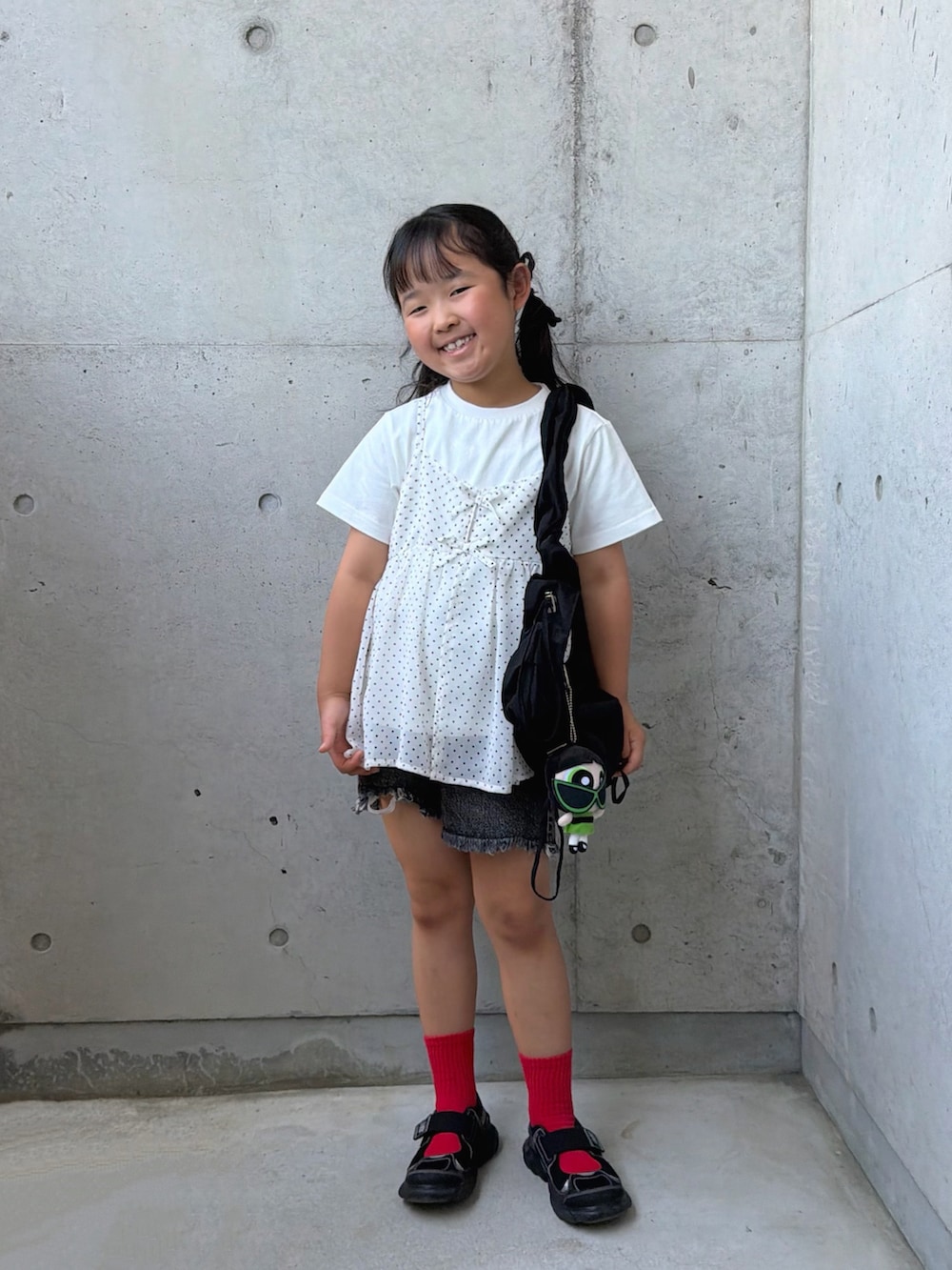 ブラック系のデニムパンツ、ホワイト系のTシャツ/カットソー、ブラック系のサンダルを着用したキッズの夏コーディネートの5枚目の写真
