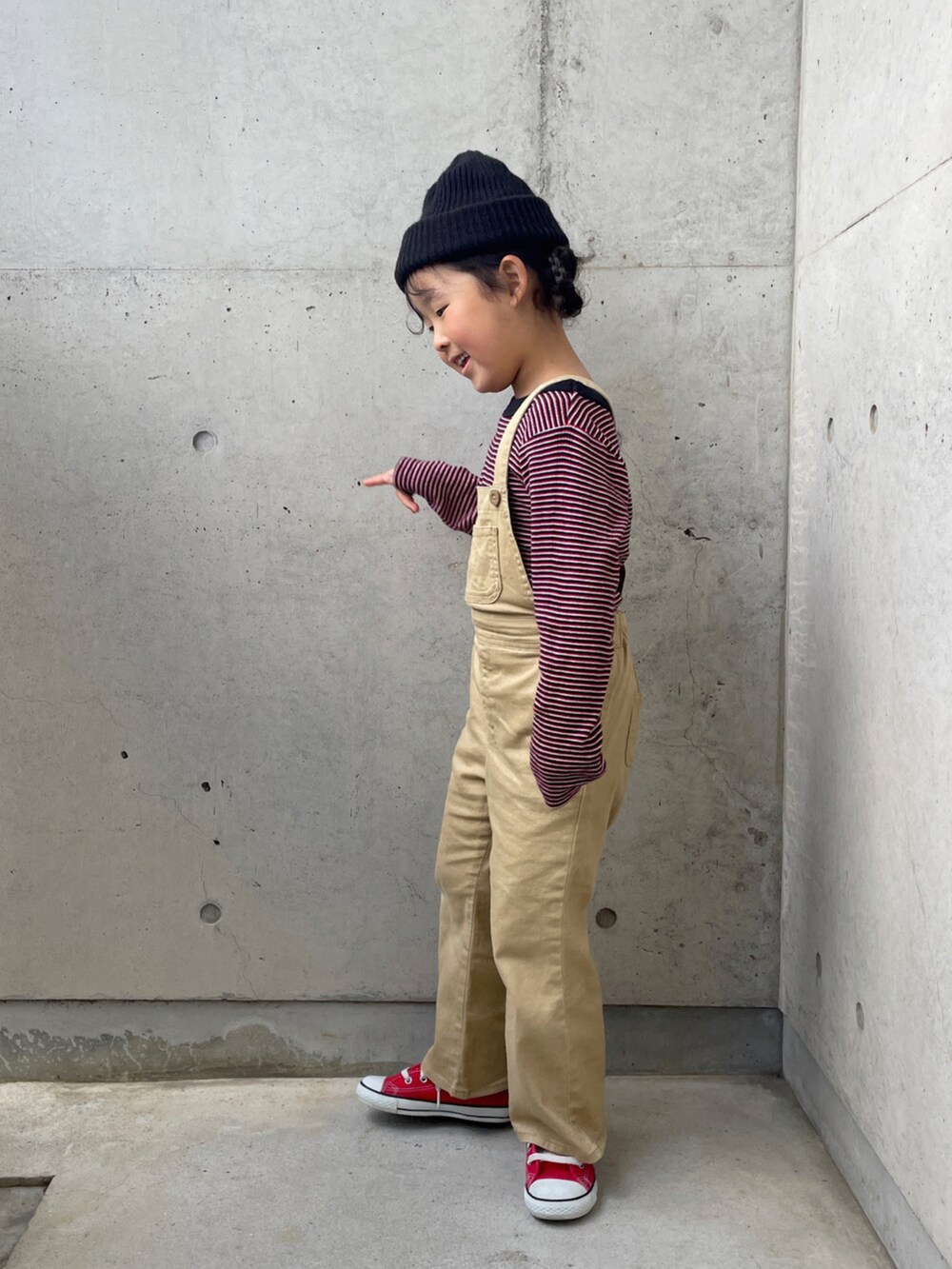 レッド系のスニーカー、レッド系のTシャツ/カットソー、ベージュ系のサロペット/オーバーオールを着用したキッズの春コーディネートの3枚目の写真