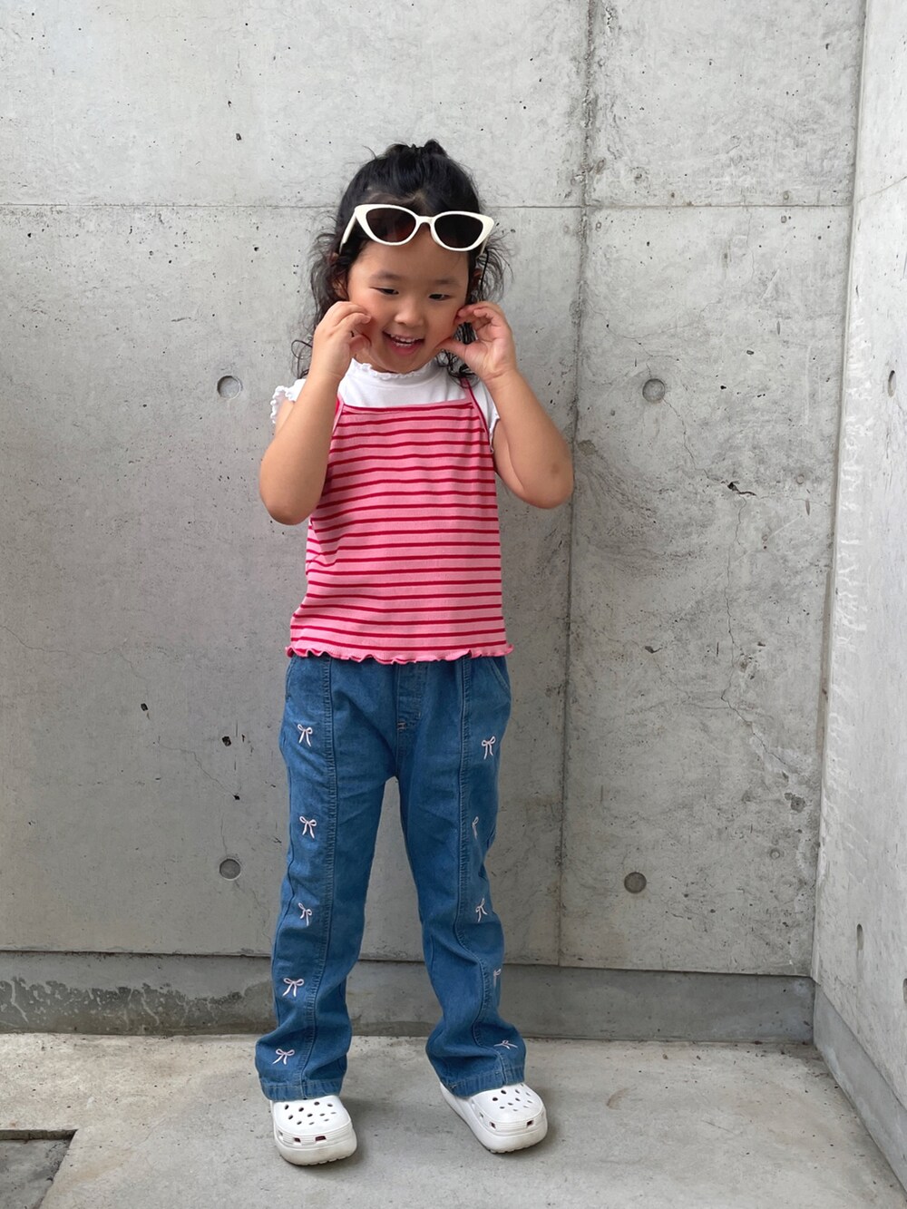 ブルー系のパンツ、ピンク系のキャミソール、ブラック系のトップスを着用したキッズの夏コーディネートの2枚目の写真