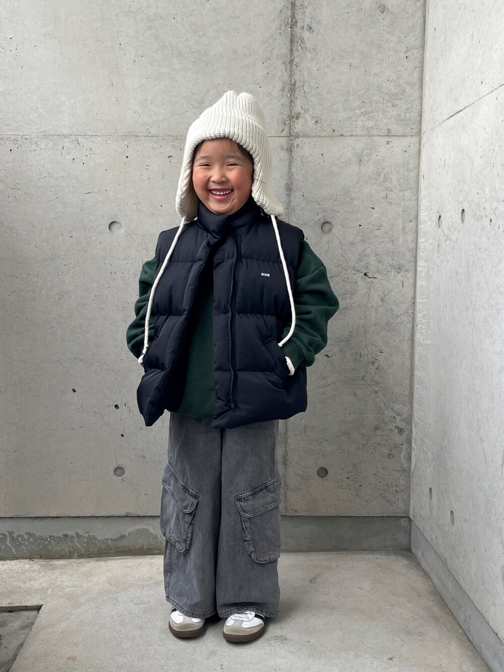 ブラック系のパンツ、ブラック系のダウンベスト、グリーン系のスウェットを着用したキッズの冬コーディネートの4枚目の写真