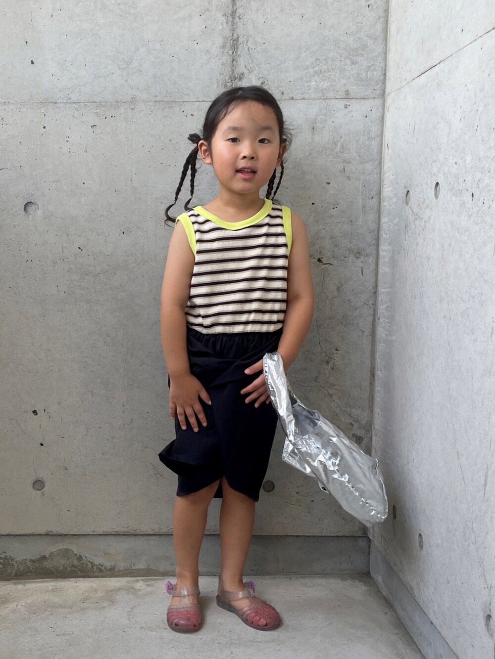 ホワイト系のサンダル、ブラック系のワンピース、シルバー系のハンドバッグを着用したキッズの夏コーディネートの5枚目の写真