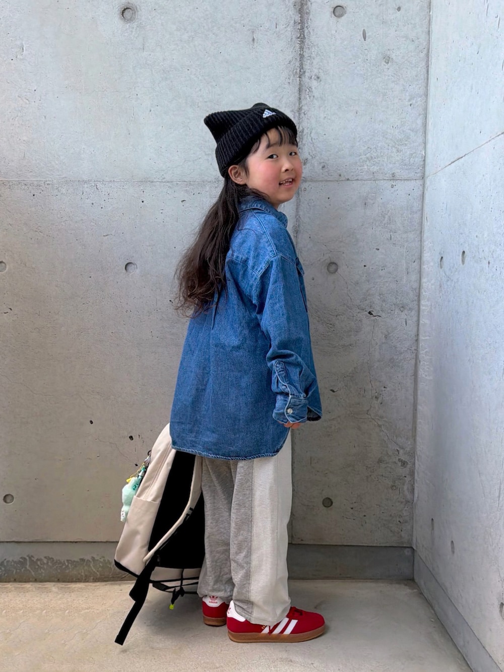 グレー系のスウェットパンツ、レッド系のスニーカー、ブルー系のシャツ/ブラウスを着用したキッズの冬コーディネートの2枚目の写真