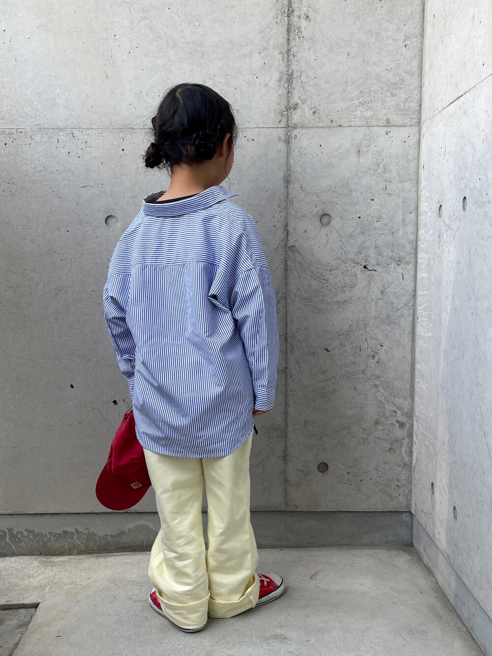 イエロー系のその他パンツ、レッド系のスニーカー、ブラック系のTシャツ/カットソーを着用したキッズの春コーディネートの3枚目の写真