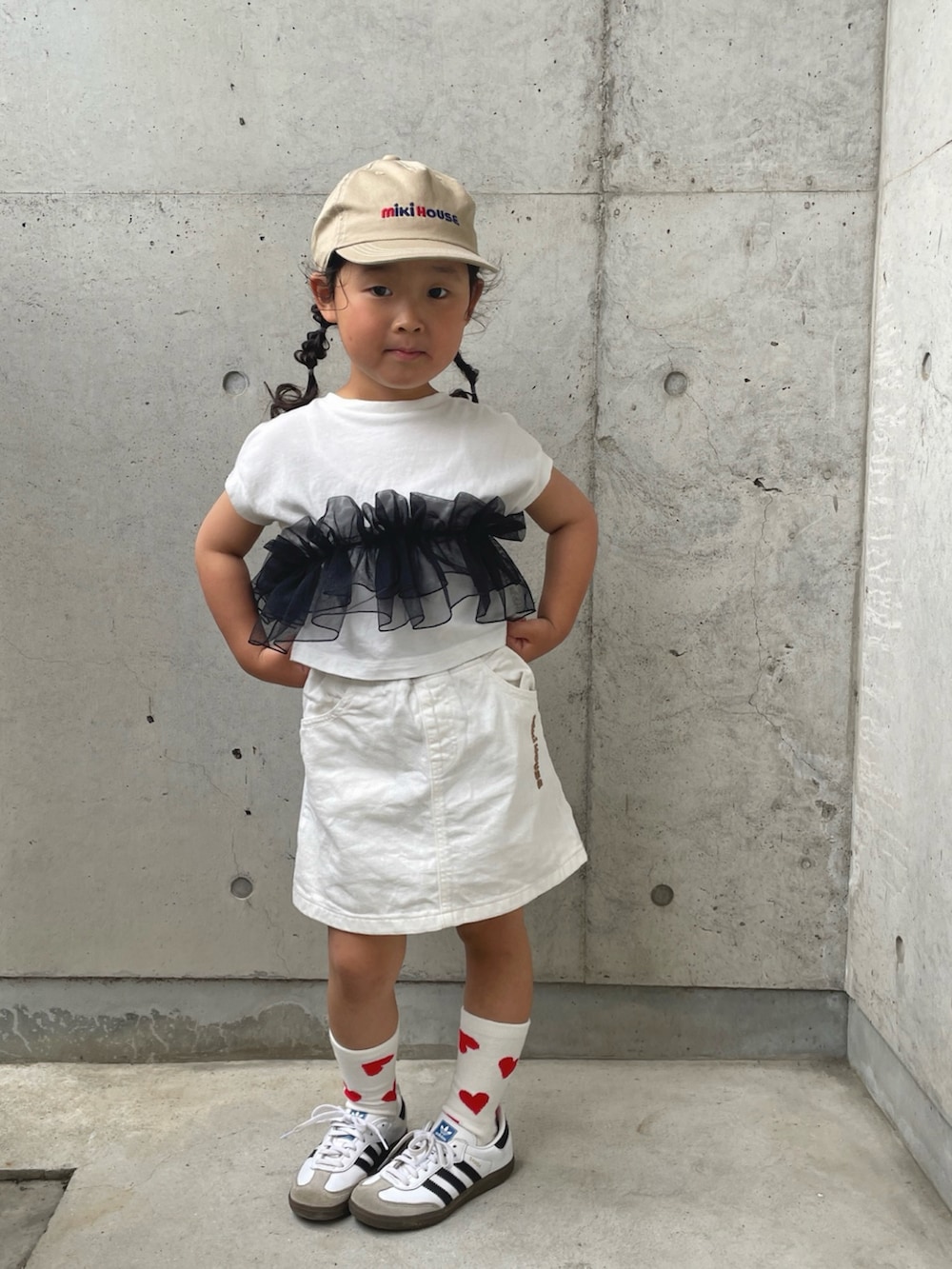 ホワイト系のスカート、ホワイト系のTシャツ/カットソー、ホワイト系のスニーカーを着用したキッズの春コーディネートの2枚目の写真