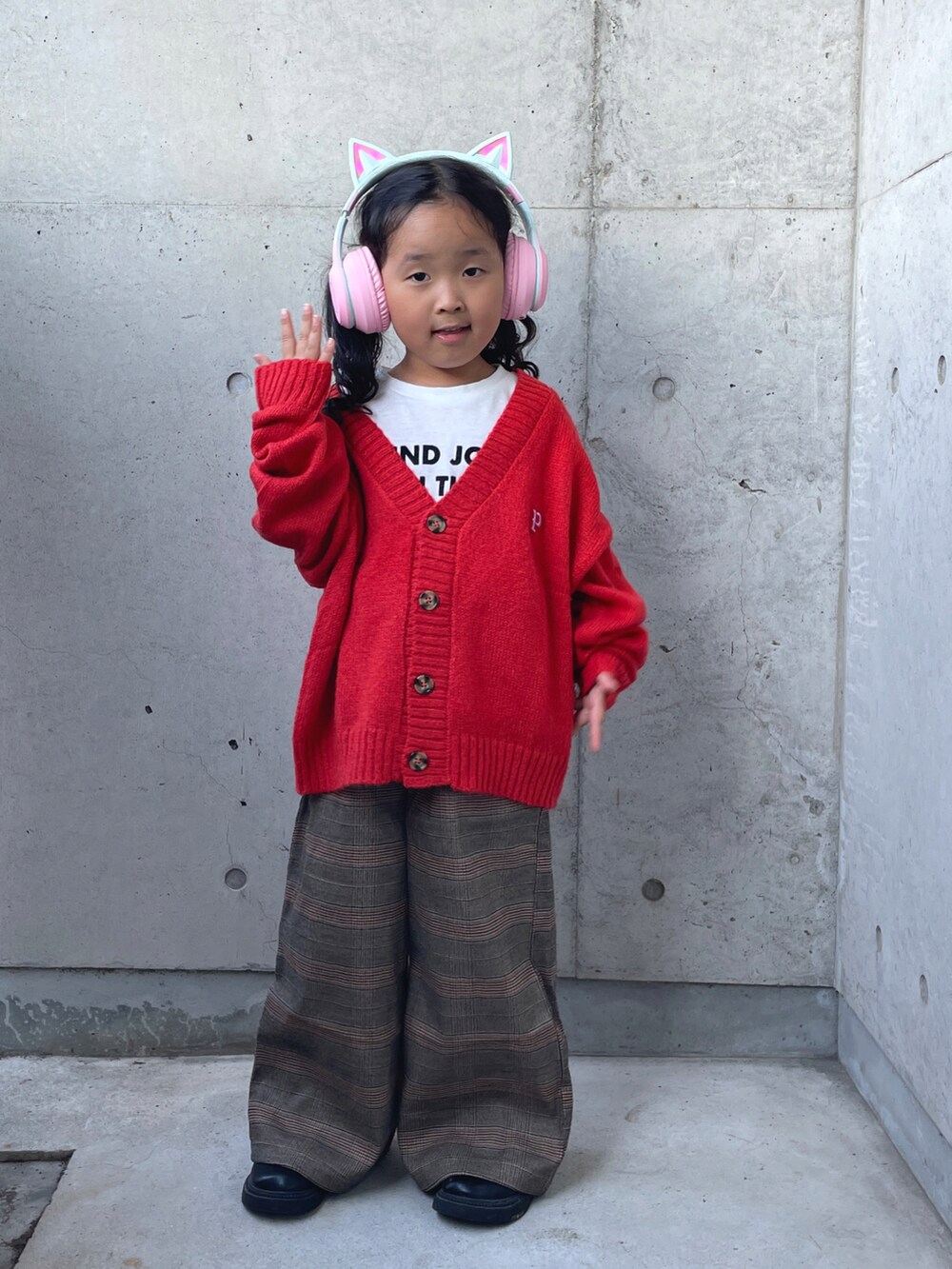 オレンジ系のカーディガン/ボレロ、ブラウン系のパンツ、ホワイト系のTシャツ/カットソーを着用したキッズの秋コーディネートの5枚目の写真