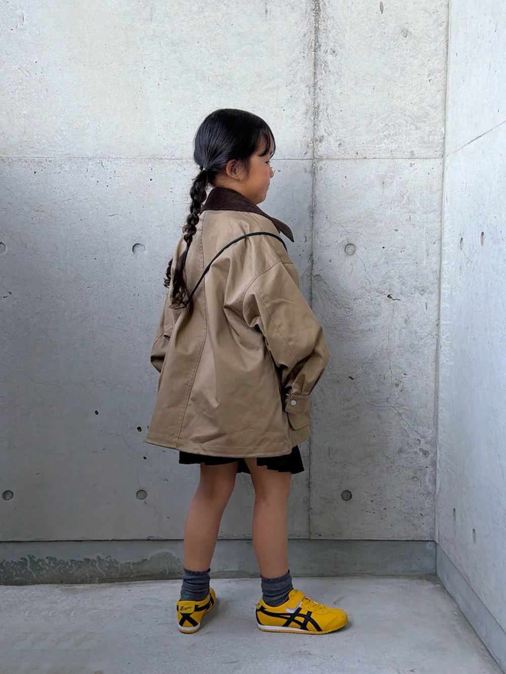 グレー系のTシャツ/カットソー、ベージュ系のミリタリージャケット、イエロー系のスニーカーを着用したキッズの秋コーディネートの5枚目の写真