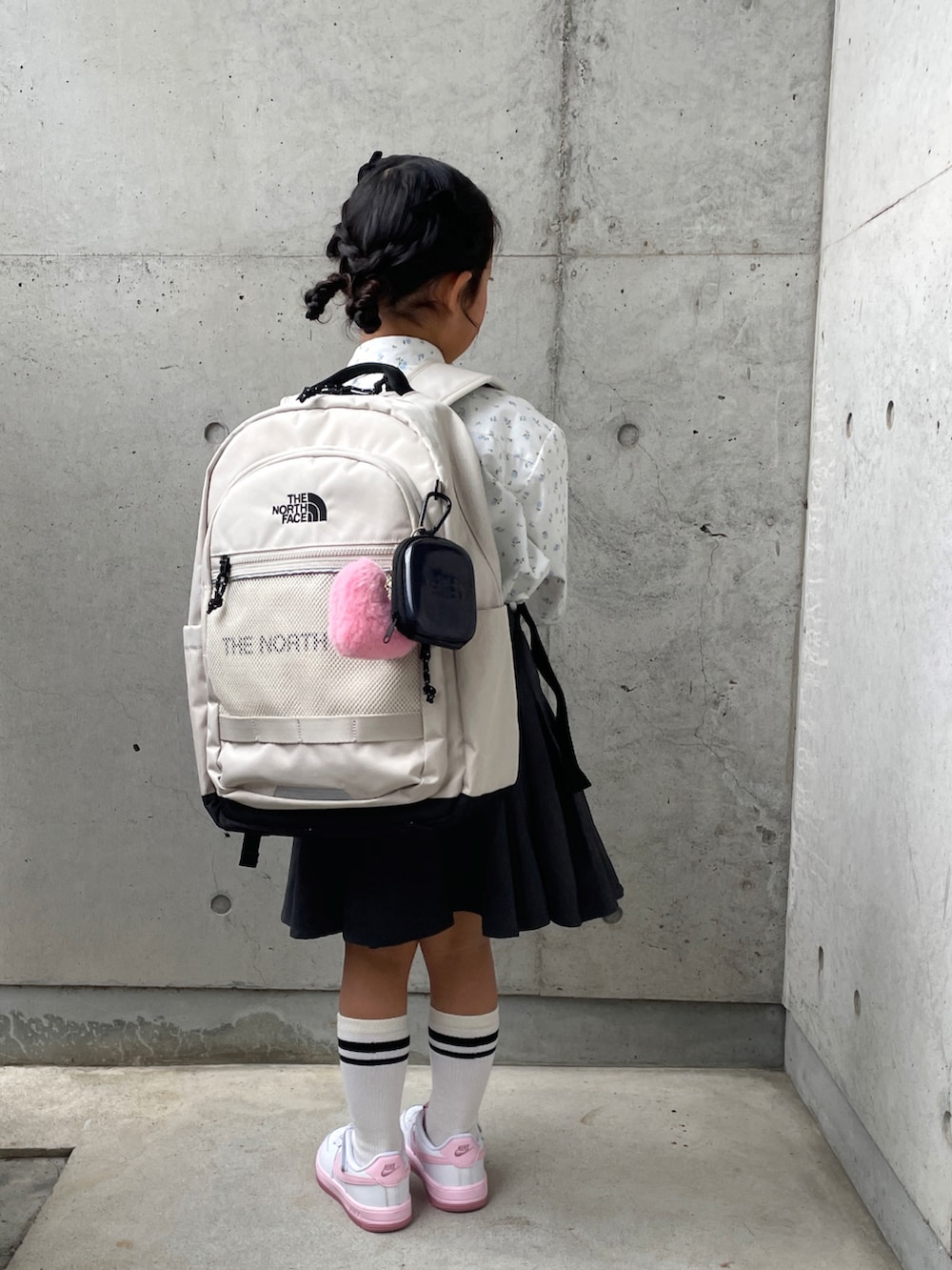 ホワイト系のスニーカー、グレー系のスカート、ホワイト系のシャツ/ブラウスを着用したキッズの春コーディネートの2枚目の写真