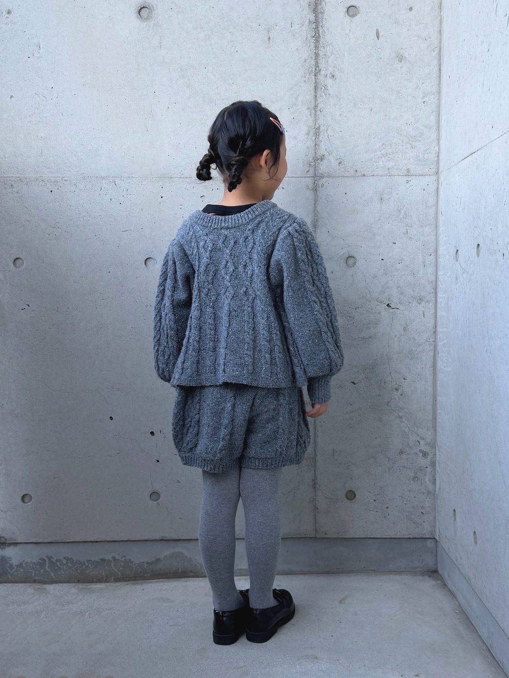 グレー系のニット/セーター、グレー系のその他パンツ、その他のローファーを着用したキッズの冬コーディネートの3枚目の写真