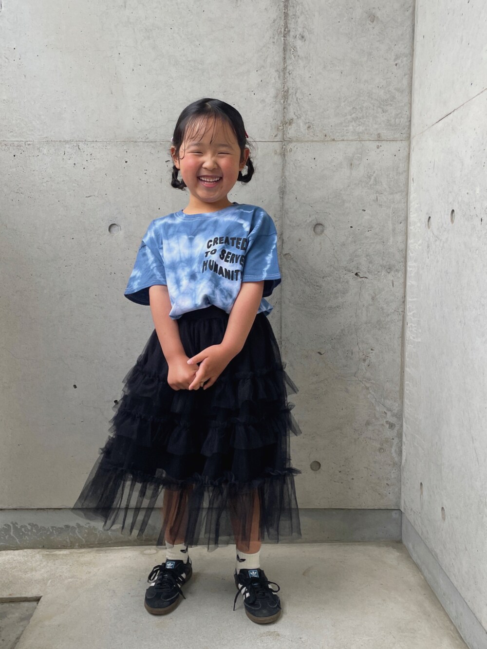 ブラック系のスカート、ブラック系のスニーカー、ブルー系のTシャツ/カットソーを着用したキッズの春コーディネートの5枚目の写真