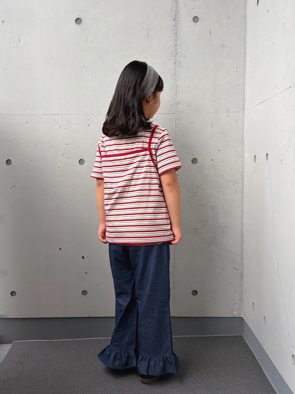 ホワイト系のTシャツ/カットソー、ブルー系のデニムパンツ、ブラック系のスニーカーを着用したキッズの秋コーディネートの3枚目の写真