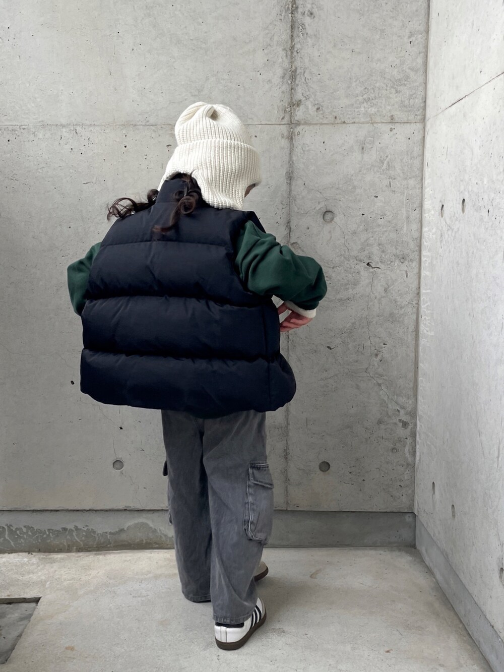 ブラック系のパンツ、ブラック系のダウンベスト、グリーン系のスウェットを着用したキッズの冬コーディネートの3枚目の写真