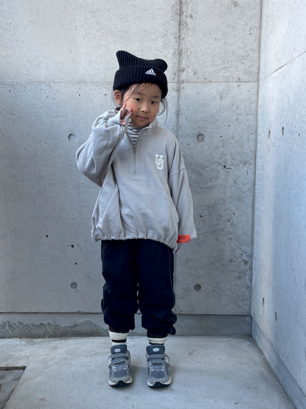 ブラック系のパンツ、ホワイト系のトップス、グレー系のスウェットを着用したキッズの冬コーディネートの4枚目の写真