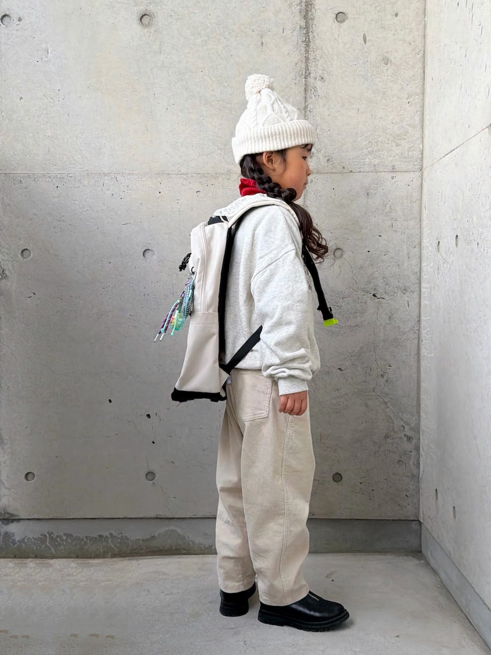 ベージュ系のスウェット、レッド系のニット/セーター、ベージュ系のその他パンツを着用したキッズの冬コーディネートの2枚目の写真