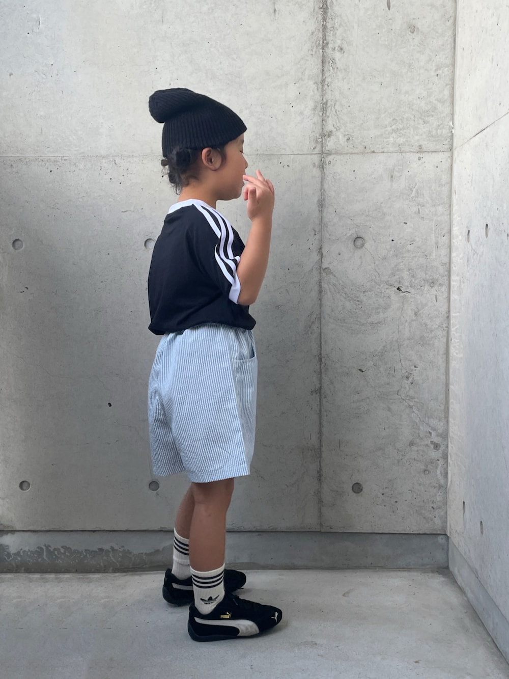 ブラック系のTシャツ/カットソー、ブラック系のスニーカー、ブルー系のパンツを着用したキッズの秋コーディネートの3枚目の写真