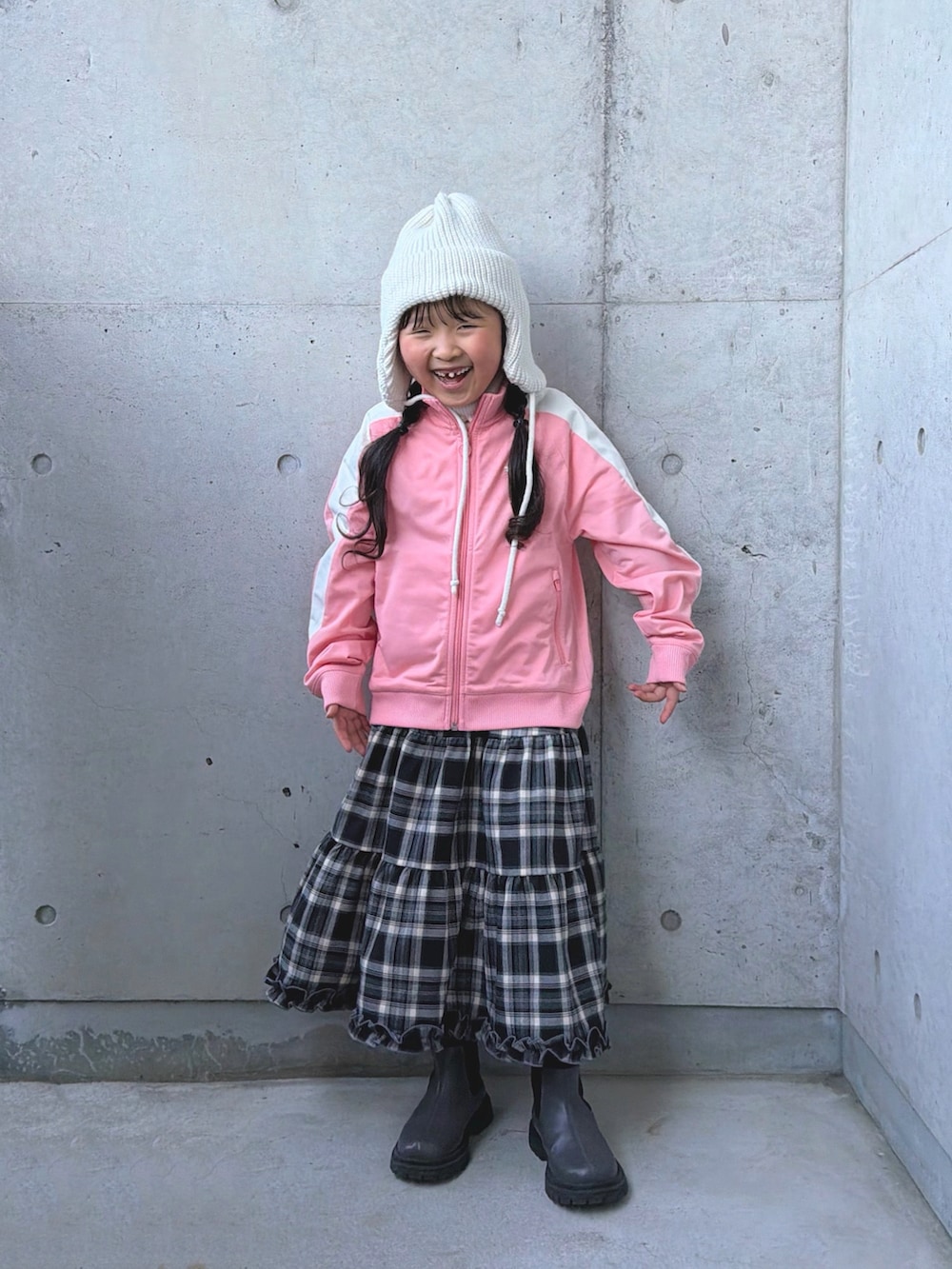 グレー系のブーツ、ピンク系のジャージ、ブラウン系のスカートを着用したキッズの冬コーディネートの3枚目の写真