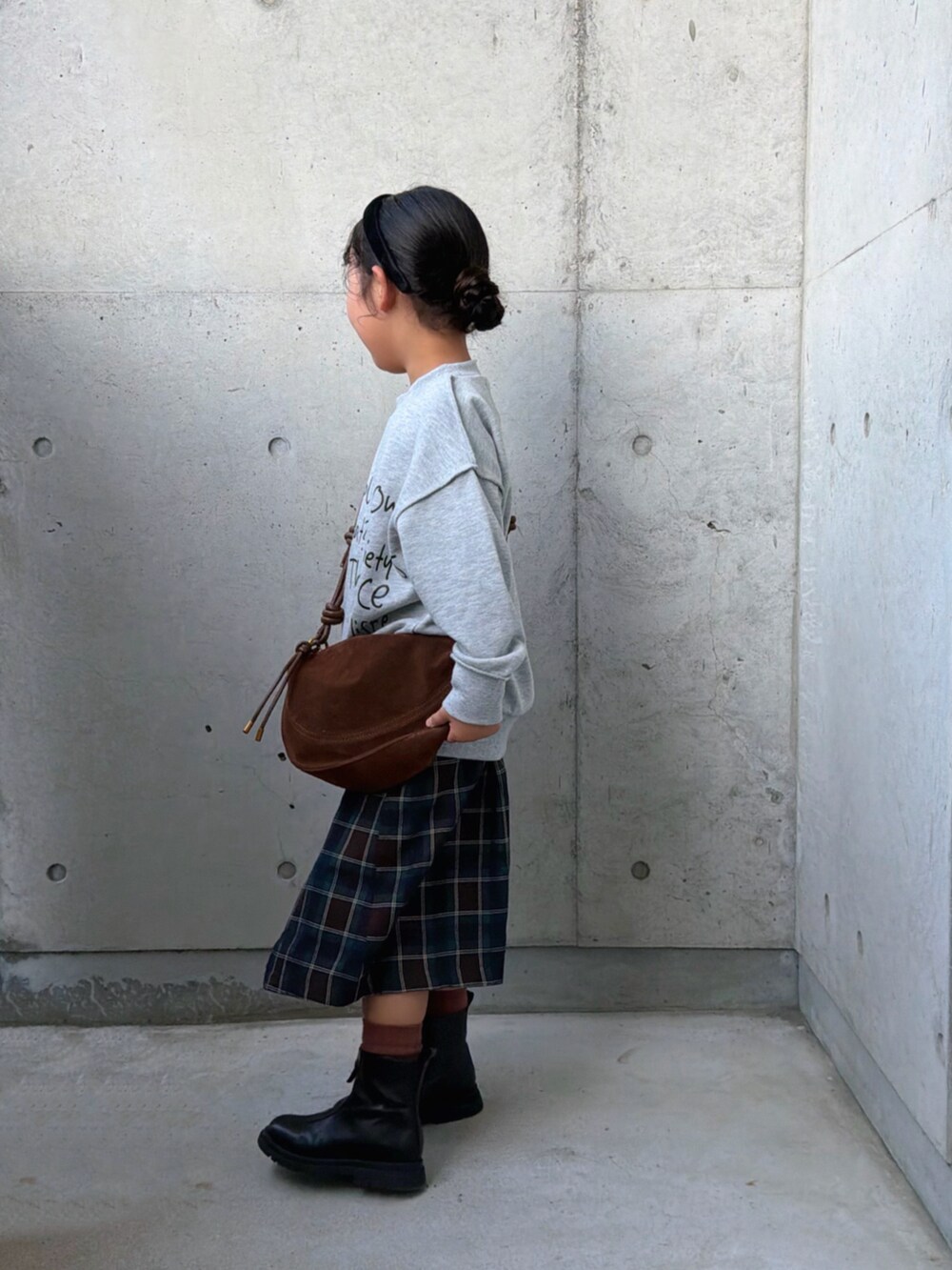 グレー系のTシャツ/カットソー、ブラウン系のスカート、ブラック系のブーツを着用したキッズの秋コーディネートの4枚目の写真