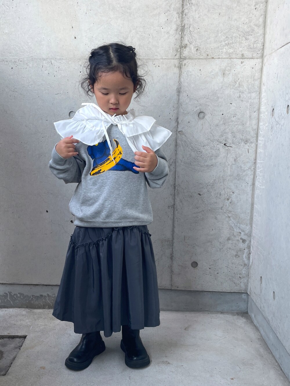 グレー系のワンピース、ブラック系のブーツ、グレー系のトップスを着用したキッズの秋コーディネートの5枚目の写真