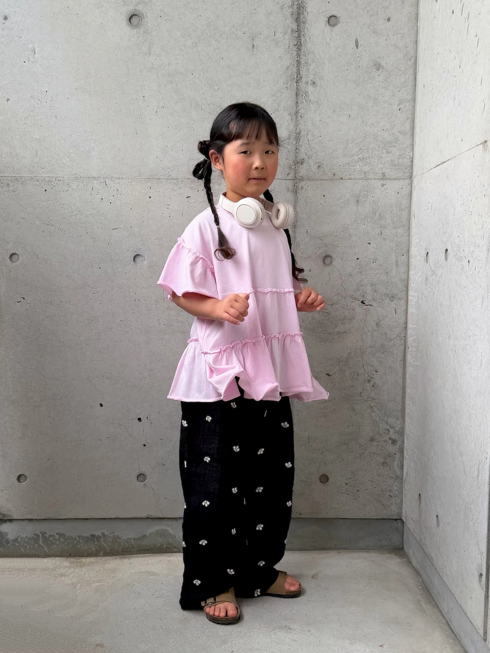 ピンク系のTシャツ/カットソー、ブラック系のその他パンツ、ベージュ系のサンダルを着用したキッズの春コーディネートの2枚目の写真