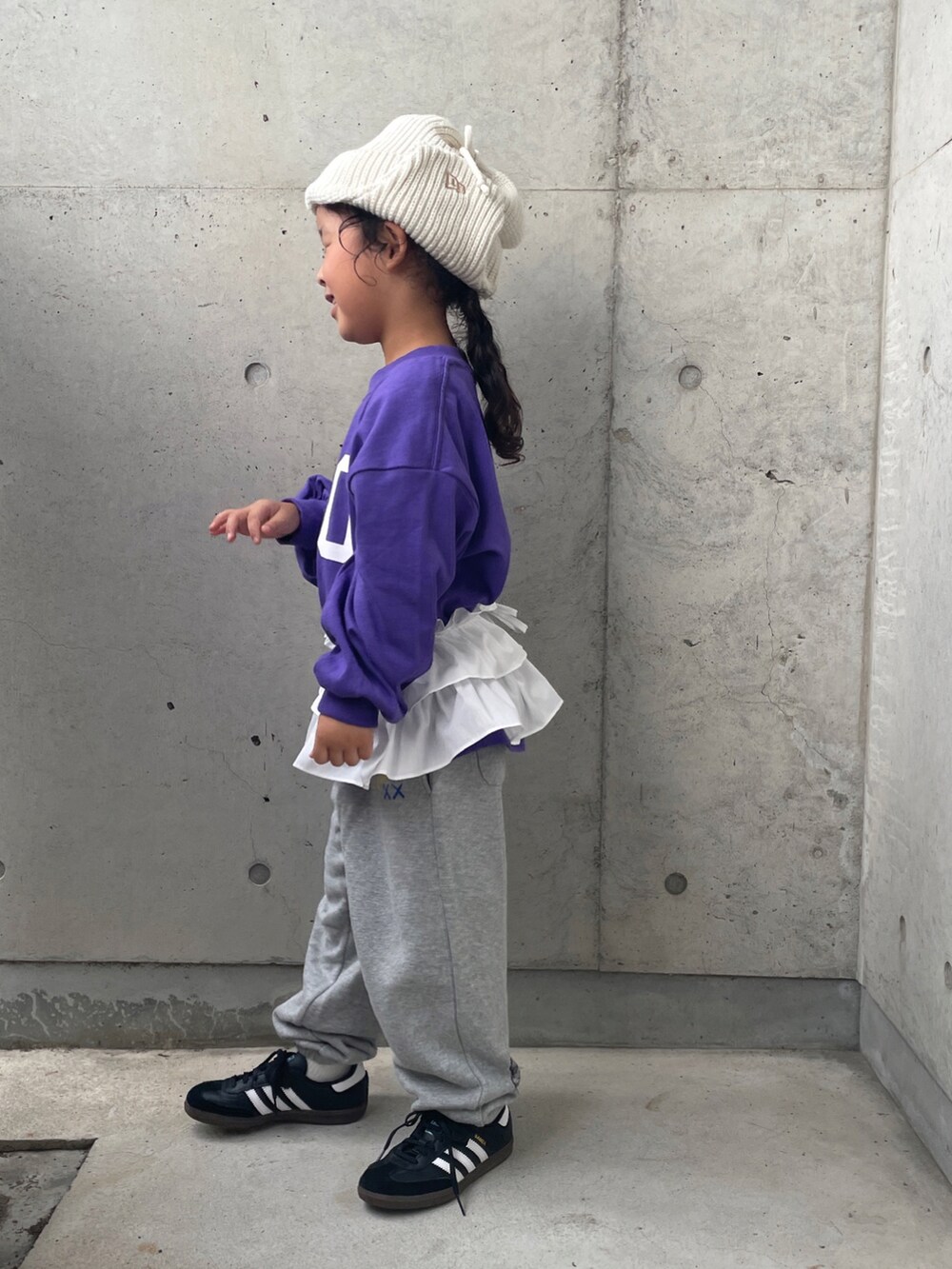 グレー系のパンツ、パープル系のTシャツ/カットソー、ブラック系のスニーカーを着用したキッズの秋コーディネートの5枚目の写真