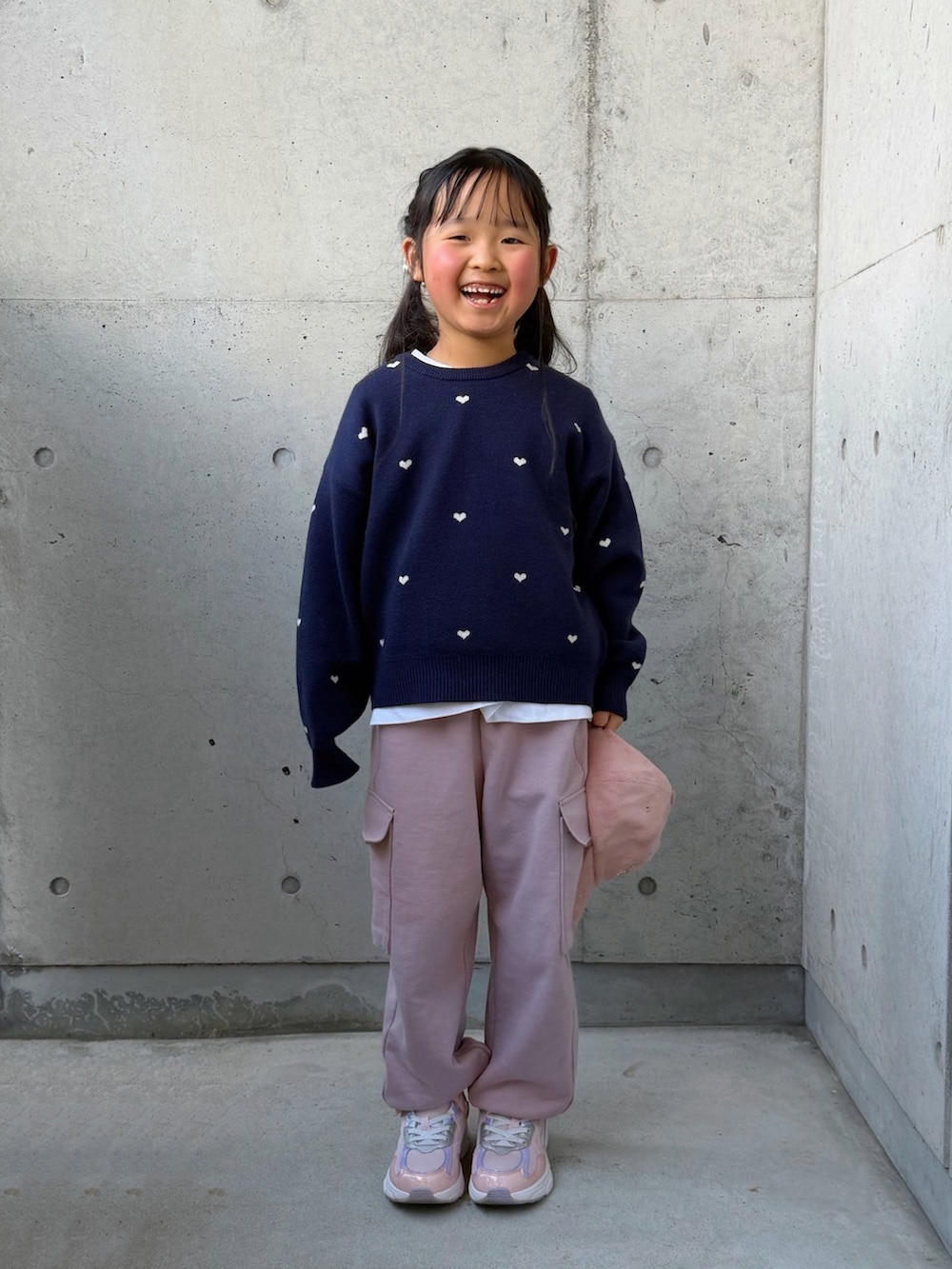 ピンク系のカーゴパンツ、ピンク系のスニーカー、ブルー系のニット/セーターを着用したキッズの冬コーディネートの3枚目の写真