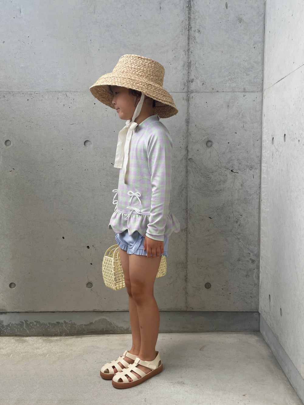 ホワイト系のサンダル、ホワイト系のバッグ、ホワイト系のハットを着用したキッズの夏コーディネートの3枚目の写真