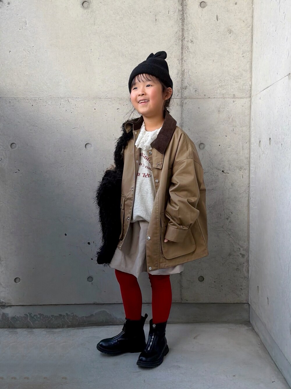 ベージュ系のスウェット、ベージュ系のスカート、ブラック系のトートバッグを着用したキッズの秋コーディネートの2枚目の写真
