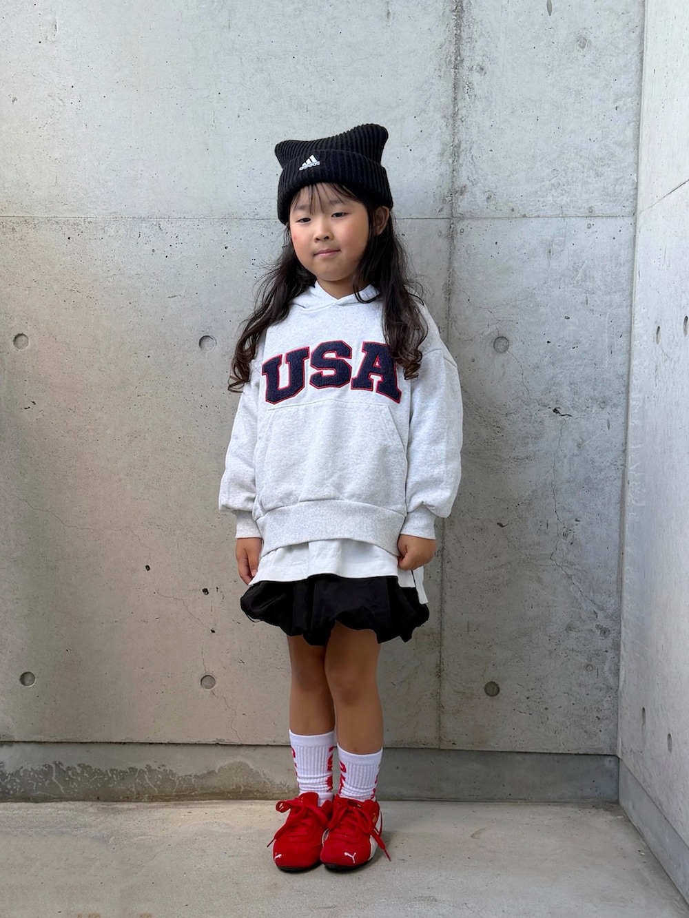 グレー系のスウェット、ブラック系のスカート、レッド系のスニーカーを着用したキッズの秋コーディネートの3枚目の写真