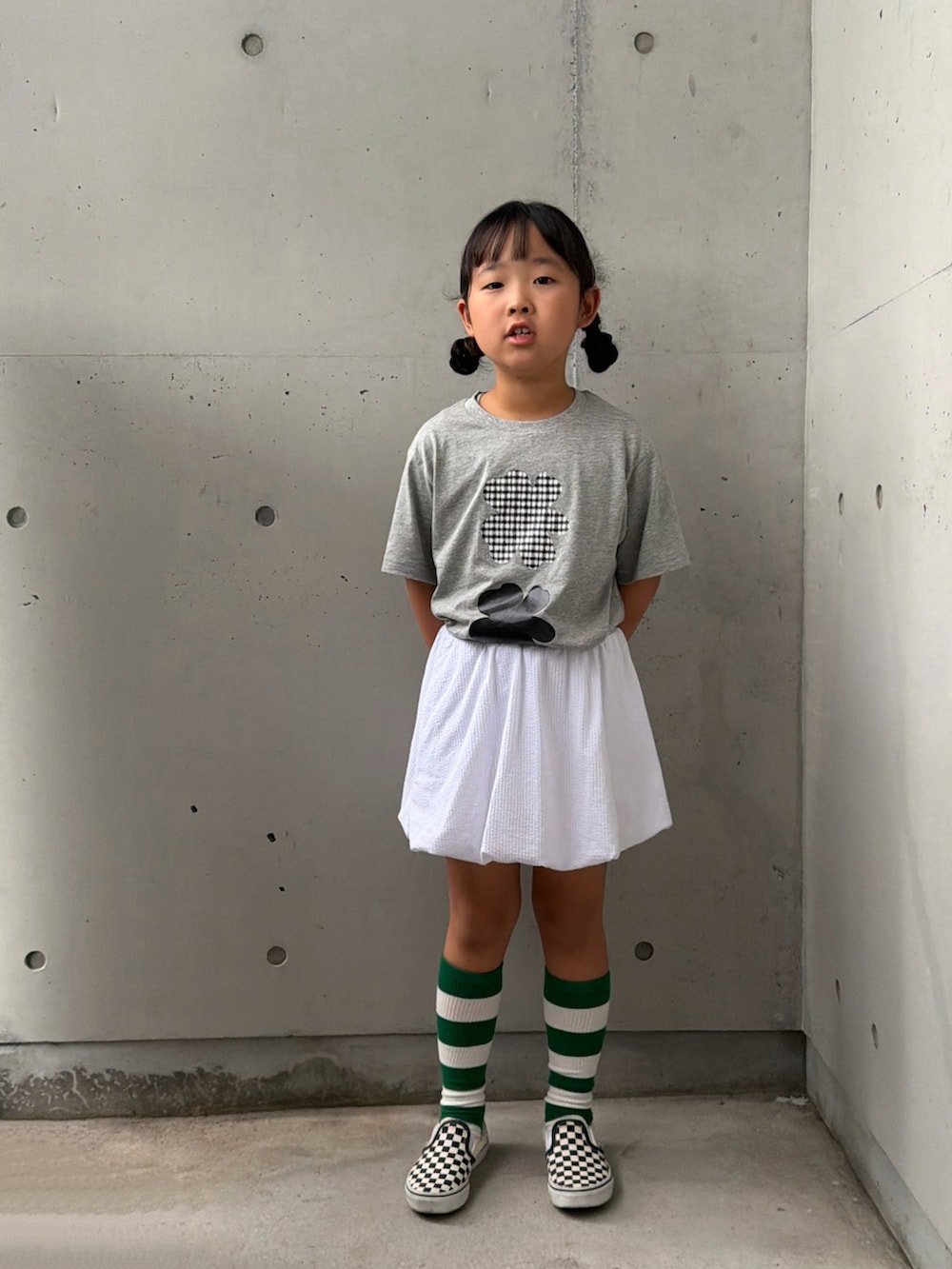 ブラック系のスリッポン、グレー系のTシャツ/カットソー、ホワイト系のスカートを着用したキッズの夏コーディネートの3枚目の写真