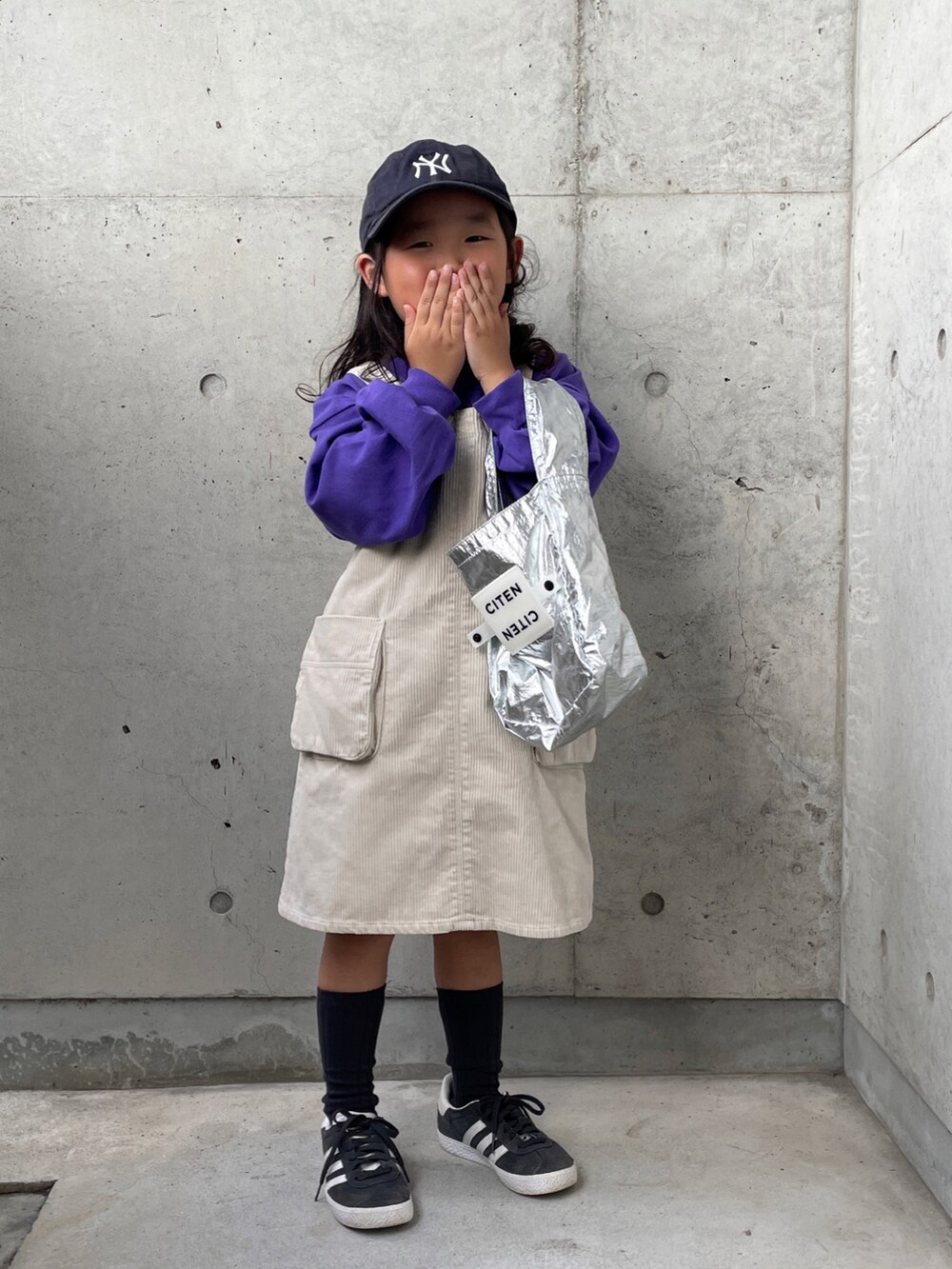 ホワイト系のオールインワン・サロペット、パープル系のTシャツ/カットソー、ブラック系のスニーカーを着用したキッズの秋コーディネートの2枚目の写真