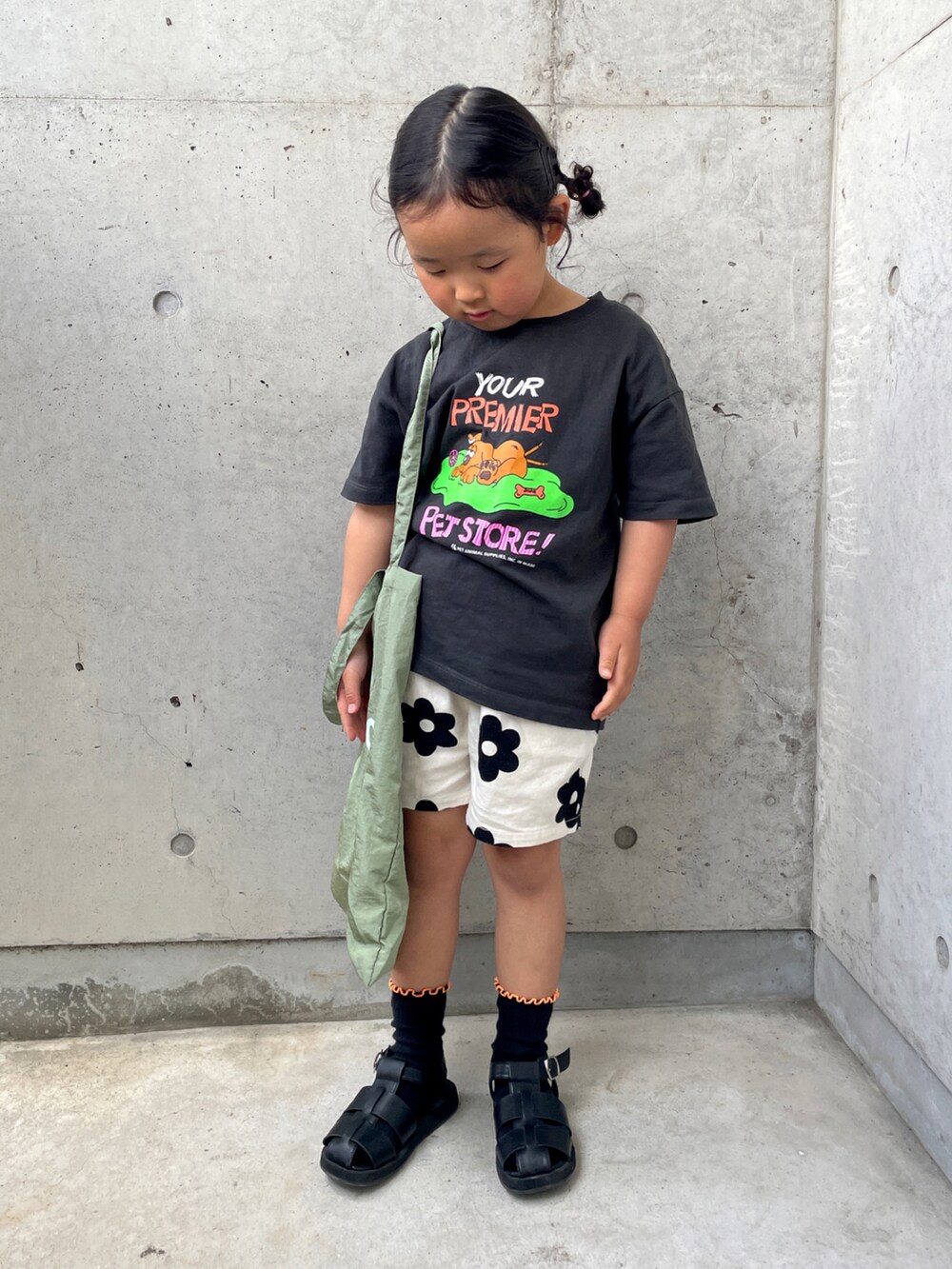 グリーン系のトートバッグ、グレー系のTシャツ/カットソー、ホワイト系のその他パンツを着用したキッズの春コーディネートの2枚目の写真