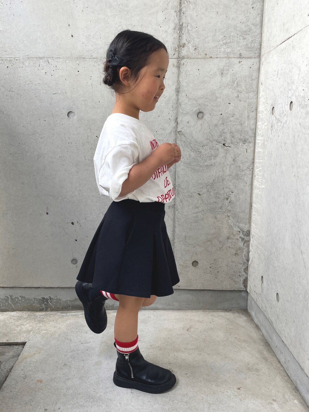 ホワイト系のTシャツ/カットソー、ブラック系のスカート、ブラック系のブーツを着用したキッズの春コーディネートの4枚目の写真