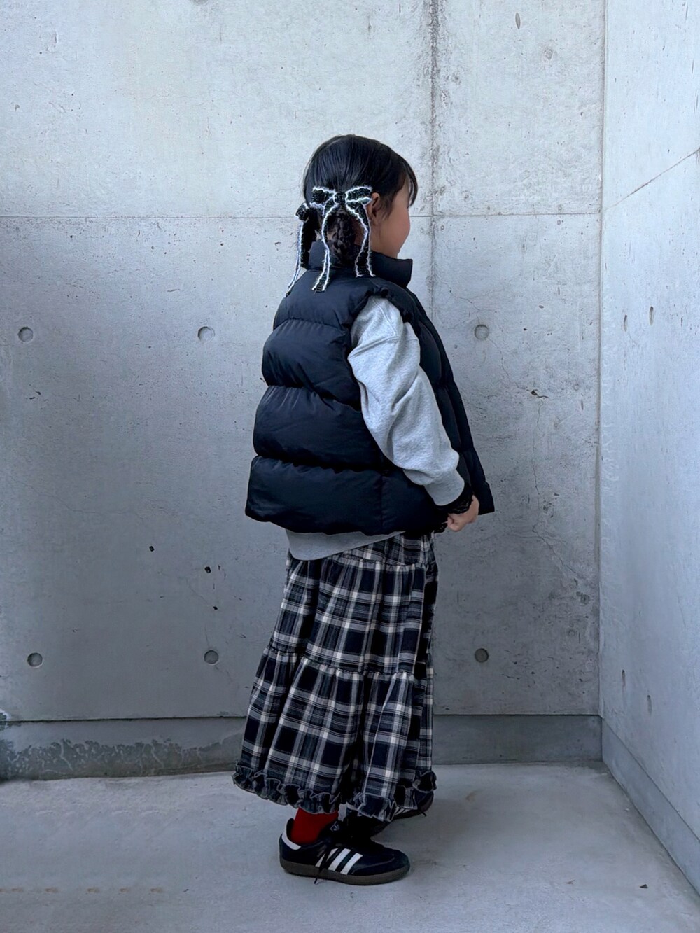 グレー系のスウェット、ブラック系のスニーカー、ブラウン系のスカートを着用したキッズの秋コーディネートの2枚目の写真