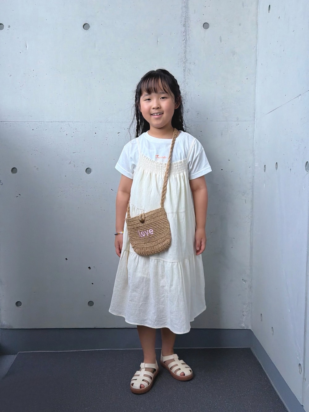 ホワイト系のサンダル、ベージュ系のショルダーバッグを着用したキッズの夏コーディネートの5枚目の写真