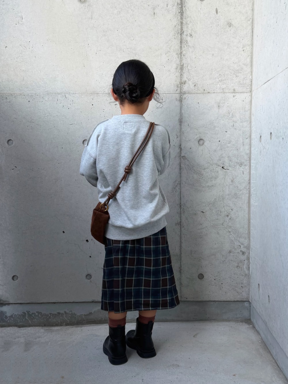 グレー系のTシャツ/カットソー、ブラウン系のスカート、ブラック系のブーツを着用したキッズの秋コーディネートの2枚目の写真