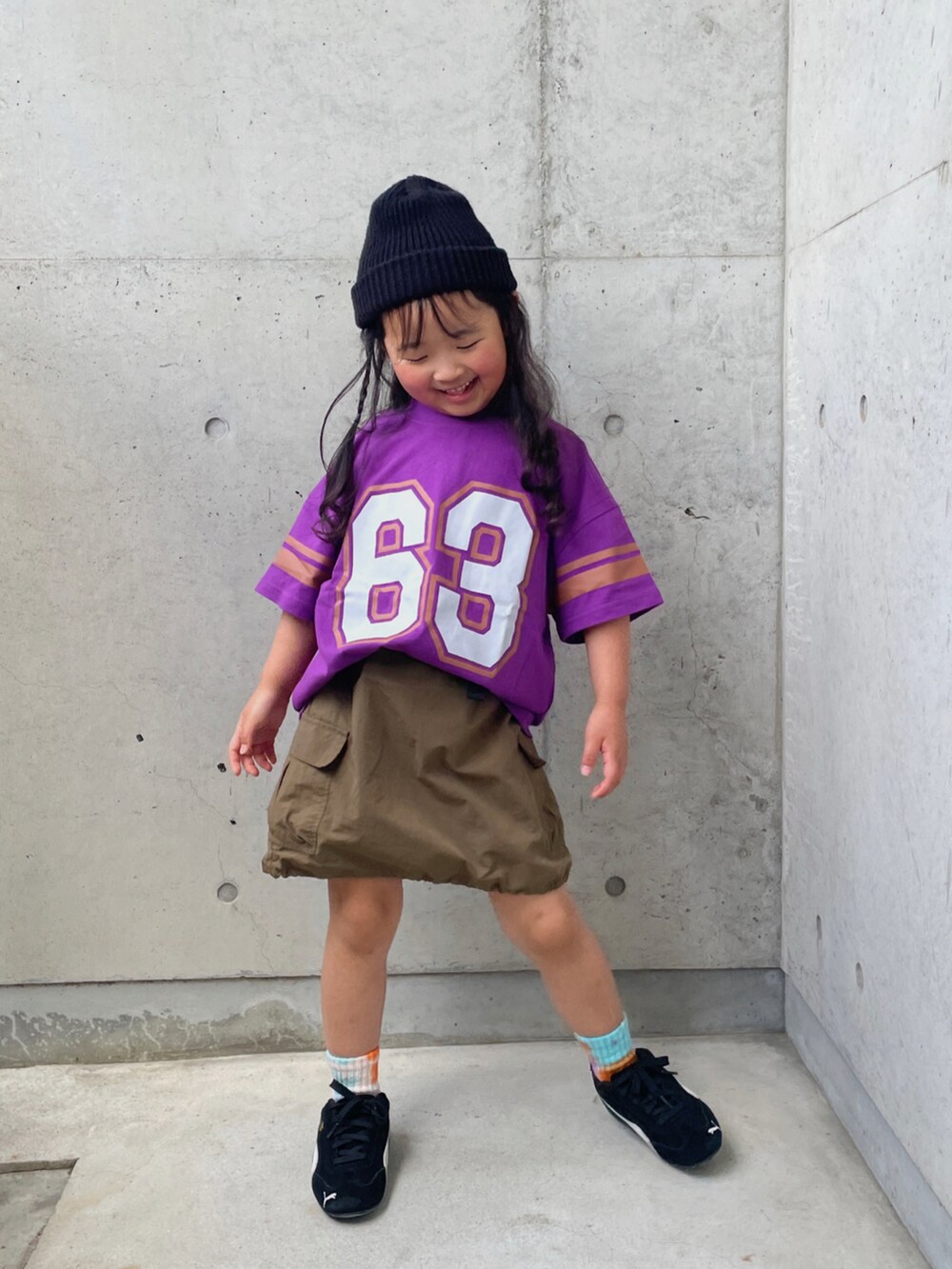 パープル系のTシャツ/カットソー、グリーン系のスカート、ブラック系のスニーカーを着用したキッズの春コーディネートの4枚目の写真