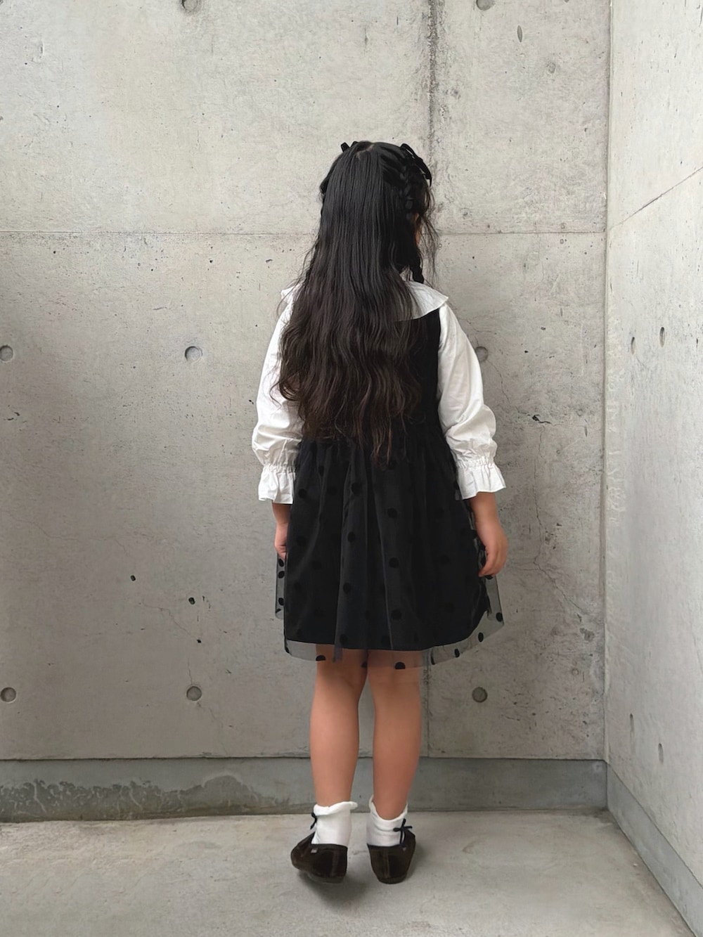 ホワイト系のシャツ/ブラウス、ブラック系のワンピース、ブラウン系のバレエシューズを着用したキッズの冬コーディネートの5枚目の写真