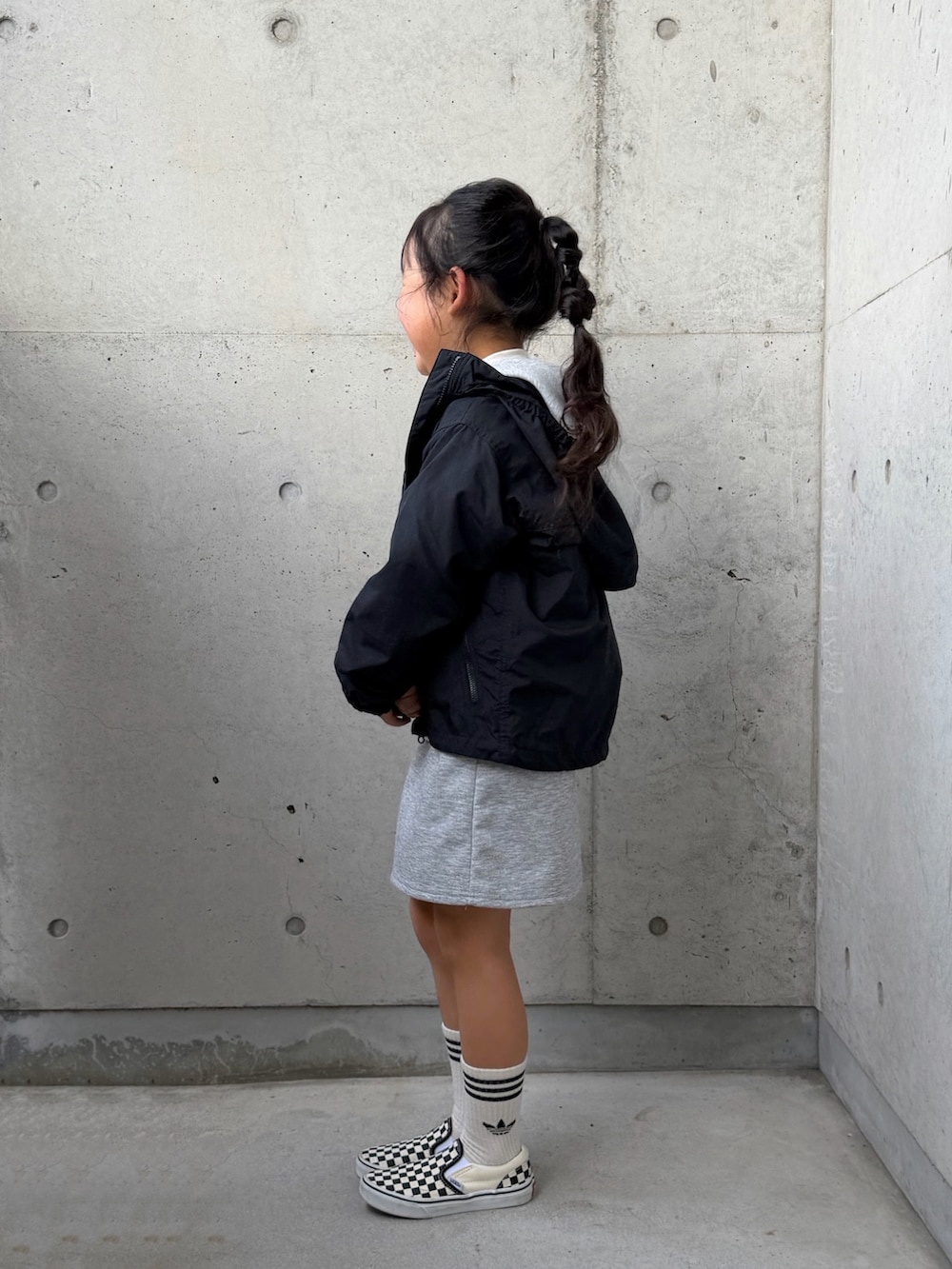 ブラック系のスニーカー、ブラック系のマウンテンパーカー、グレー系のパーカーを着用したキッズの冬コーディネートの5枚目の写真