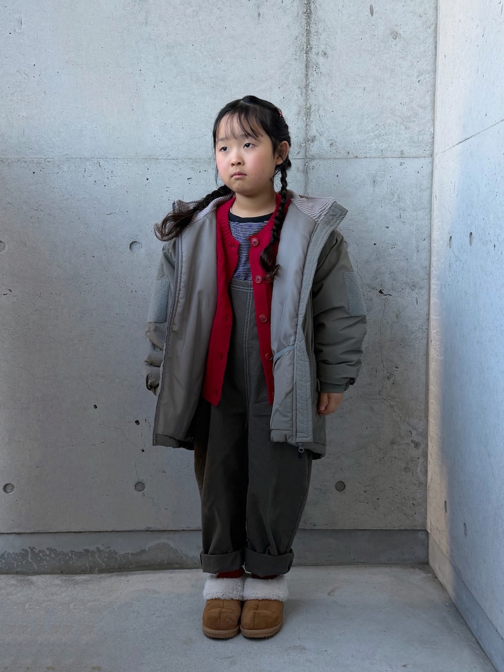 グレー系のサロペット/オーバーオール、ブラウン系のブーツ、ブラック系のTシャツ/カットソーを着用したキッズの冬コーディネートの5枚目の写真