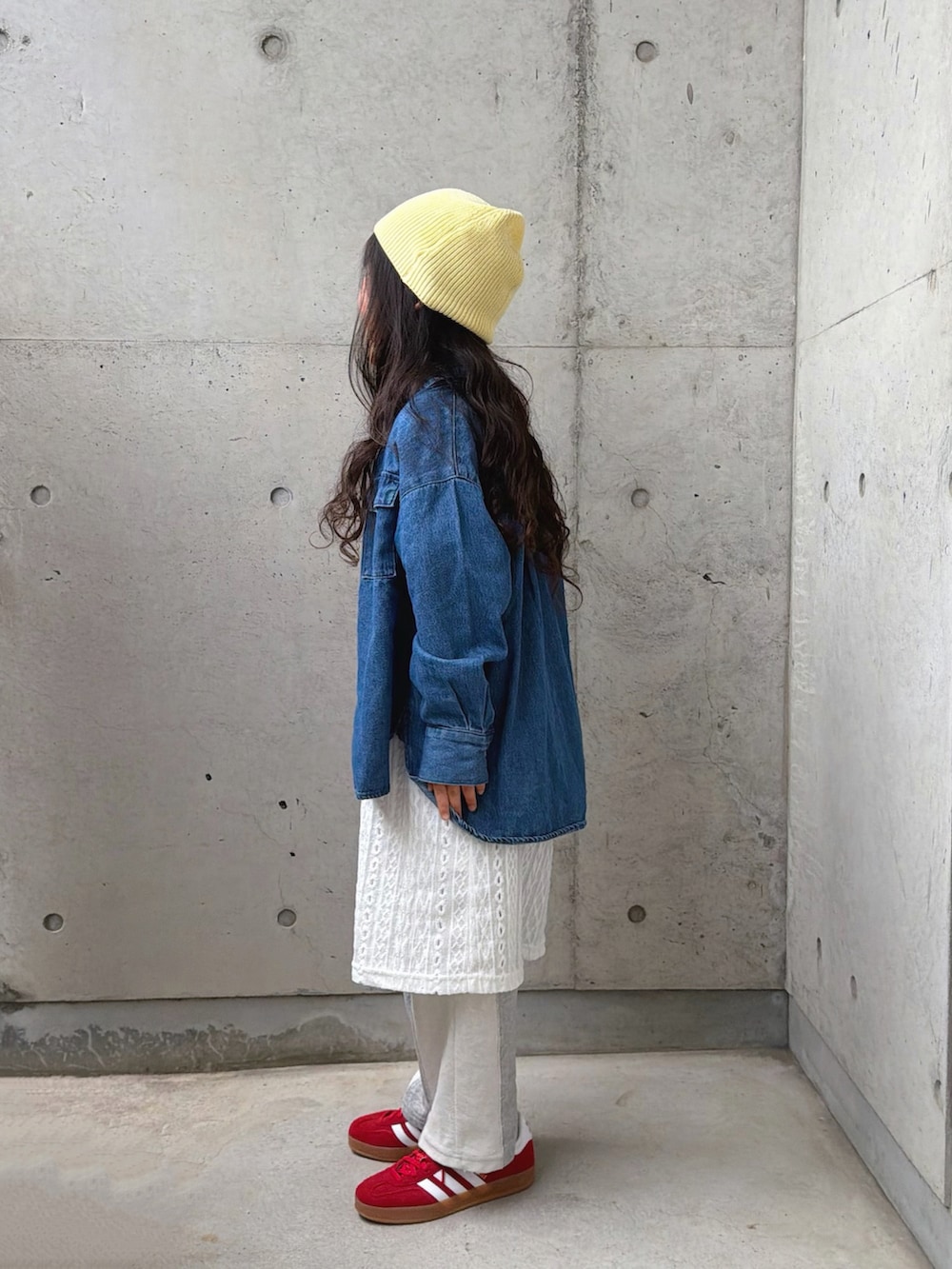 グレー系のスウェットパンツ、レッド系のスニーカー、ホワイト系のワンピースを着用したキッズの春コーディネートの2枚目の写真