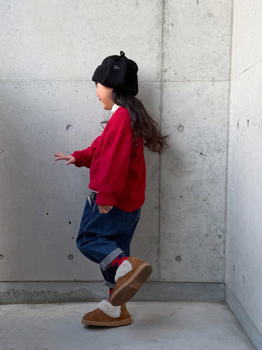 ホワイト系のニット/セーター、ブラウン系のブーツ、ブルー系のデニムパンツを着用したキッズの秋コーディネートの2枚目の写真