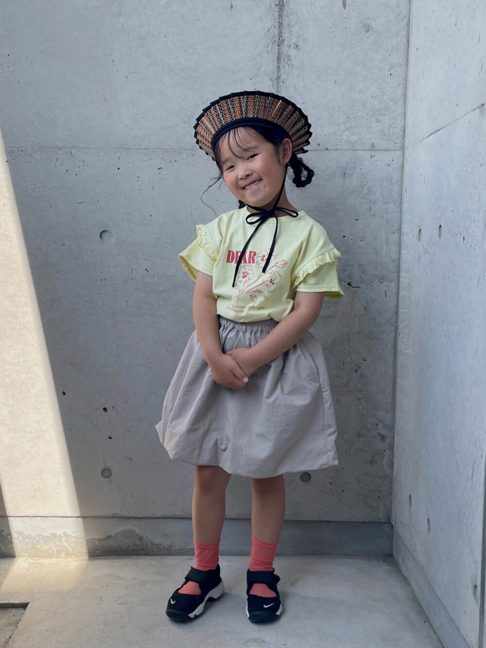 ブラック系のスニーカー、ベージュ系のTシャツ/カットソー、ベージュ系のスカートを着用したキッズの夏コーディネートの4枚目の写真